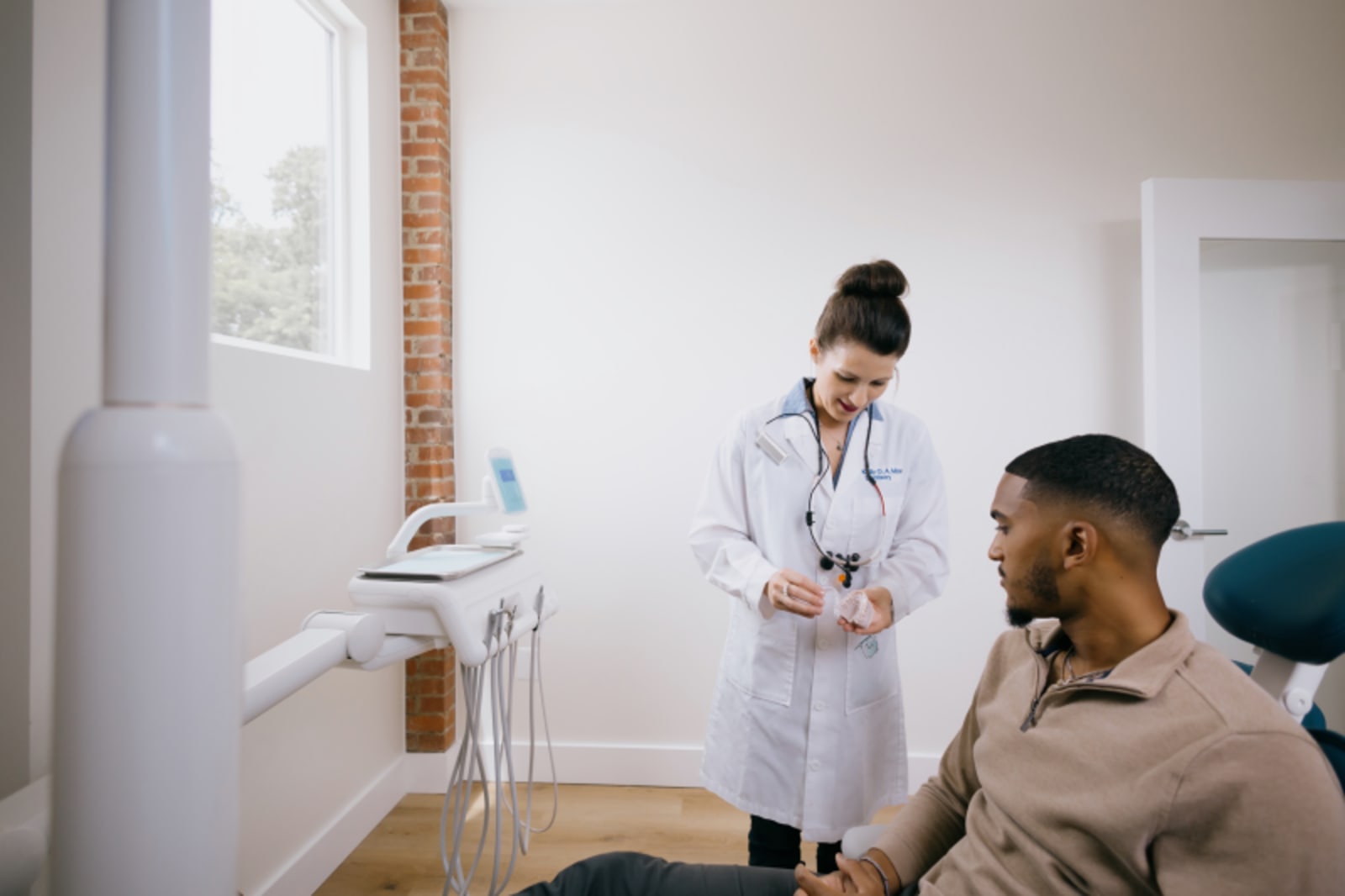 Dental team showing patient a mirror during an examination and consultation