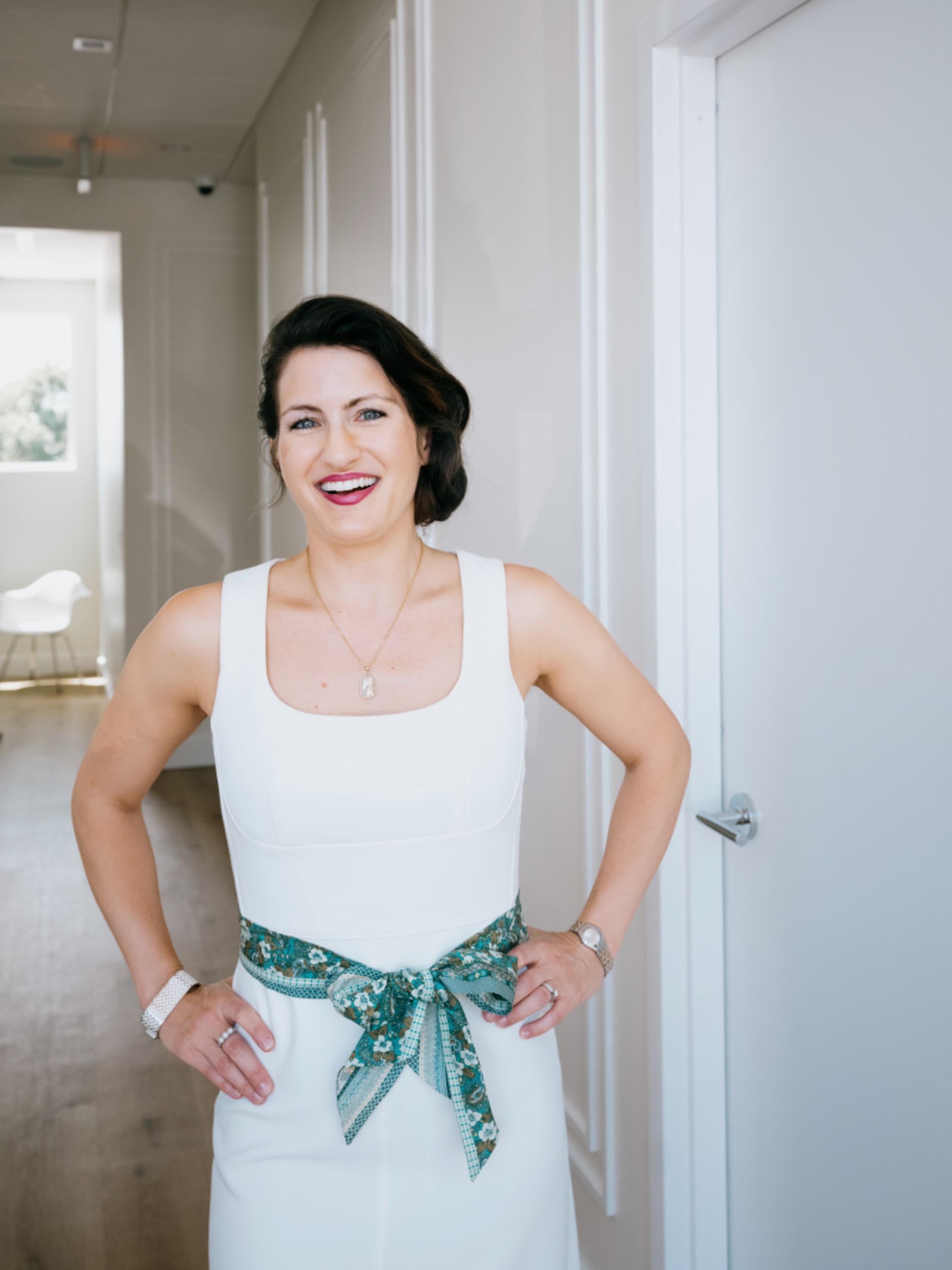 Female dentist standing confidently in a modern dental practice corridor