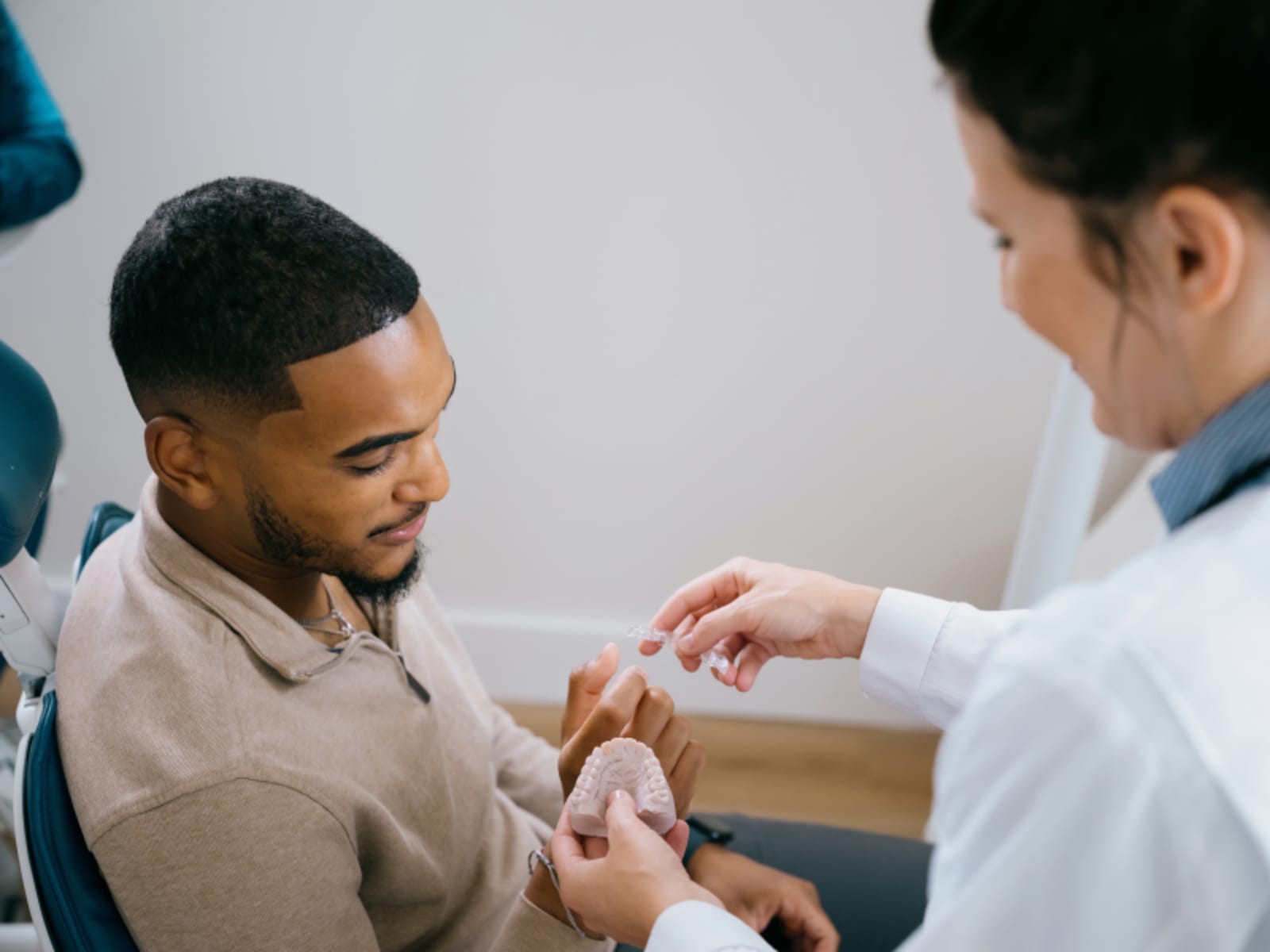 Dental professional placing IV sedation line on patient's arm during appointment preparation.