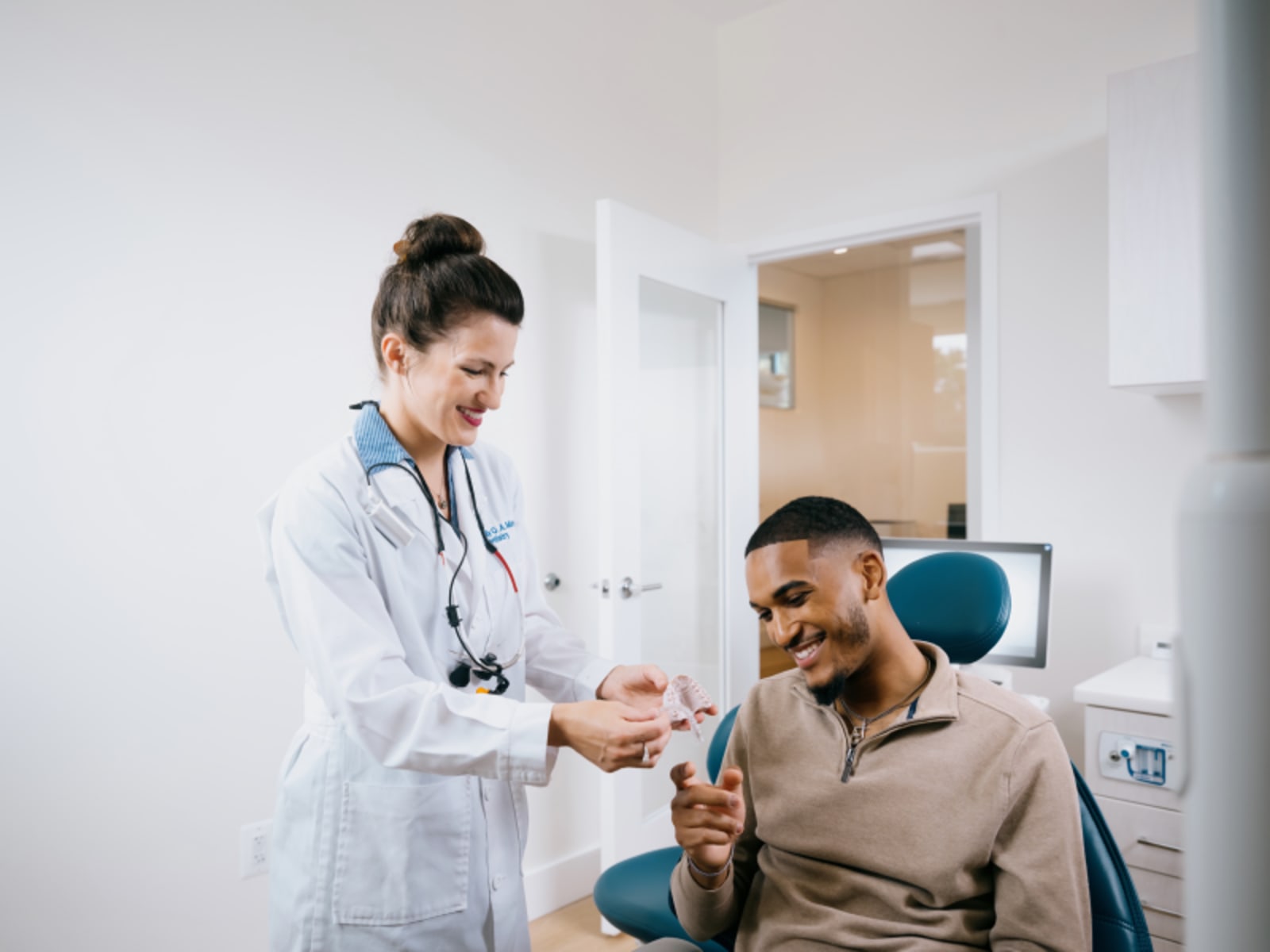 Dentist discussing X-ray results with patient at computer in office