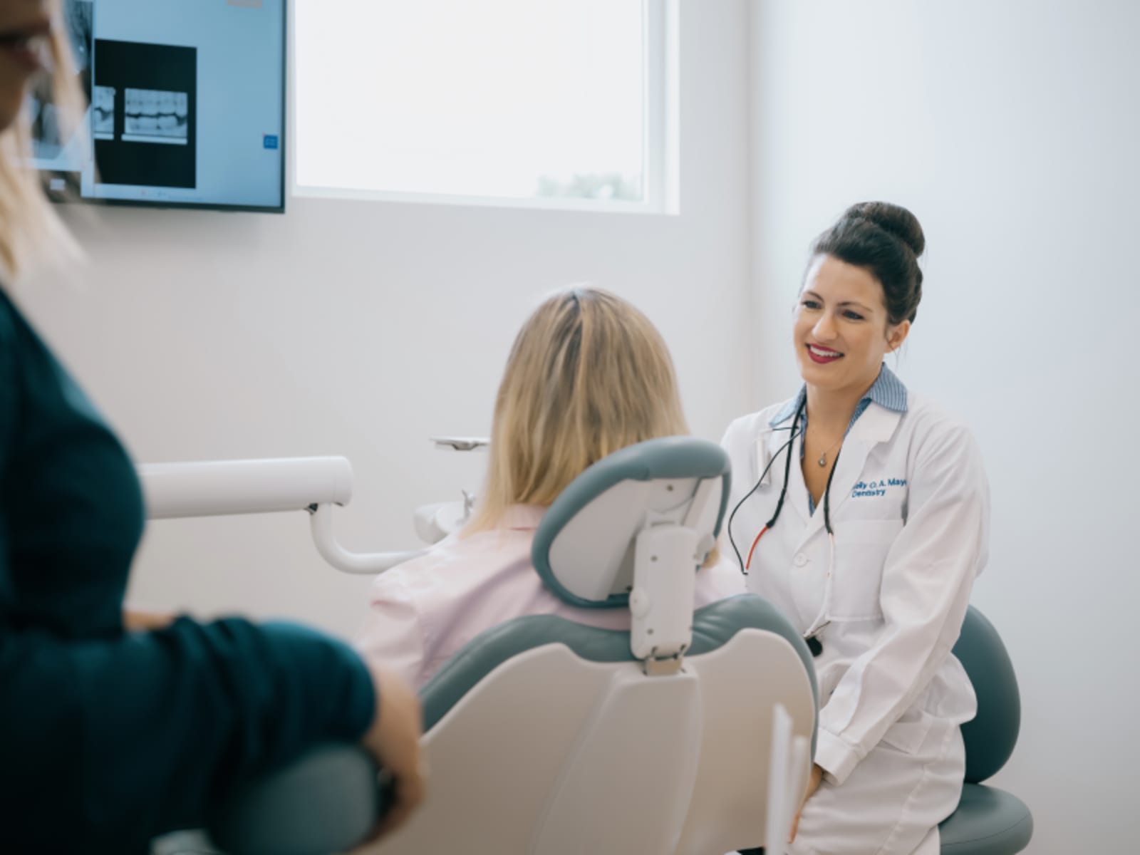 Dentist examining patient's teeth during appointment in treatment room