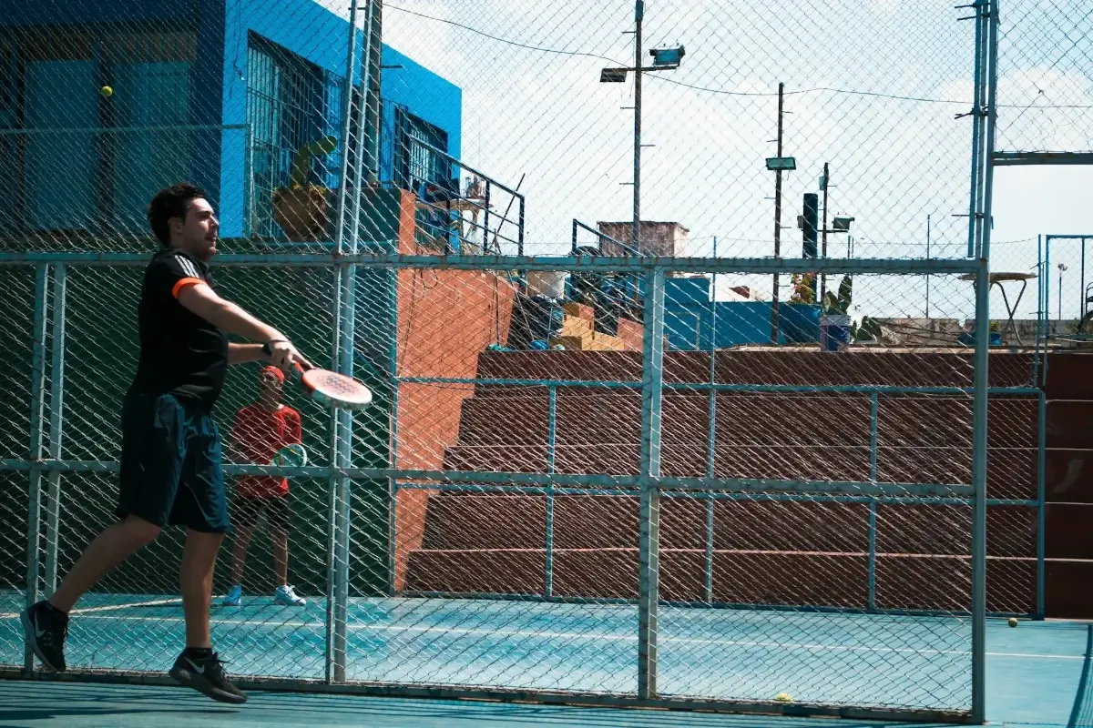 Male padel player returning the ball.