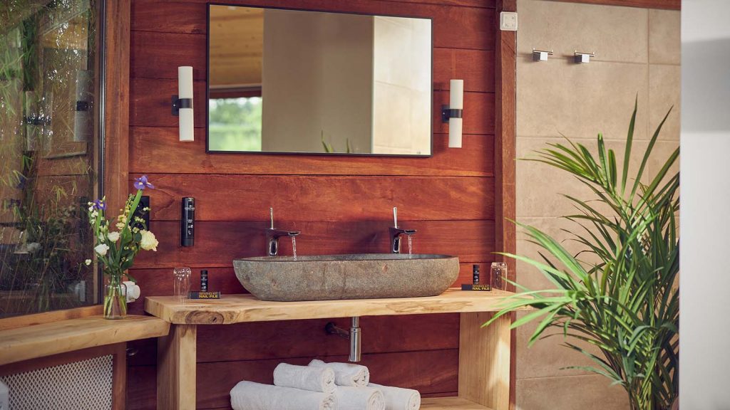 Waschbecken mit Spiegel im balinesischen Stil im Hotelzimmer Bali im Fort Resort Beemster.
