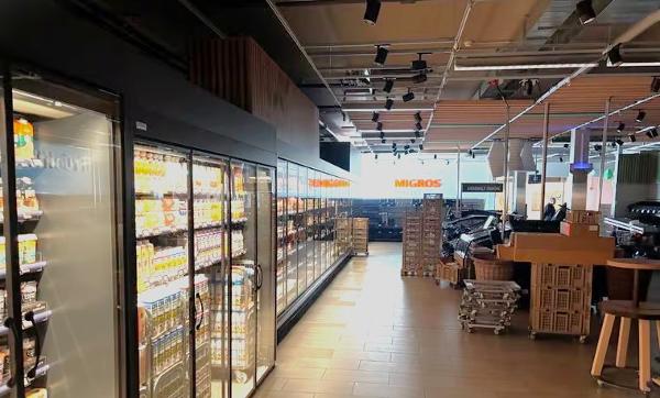 Die neuen Kühlregale mit Glastüren und das noch leere Frischesortiment im Dunkeln. Die Lichtsysteme wurden gerade getestet. (Bild: Elisha Wick)