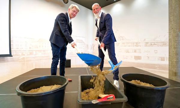 Benno Gmür (links), CEO der SBS, und Norbert Reuter, Geschäftsführer der BSB, begraben symbolisch das Kriegsbeil mit einer Schaufel Sand. (Bild: Manuel Nagel)