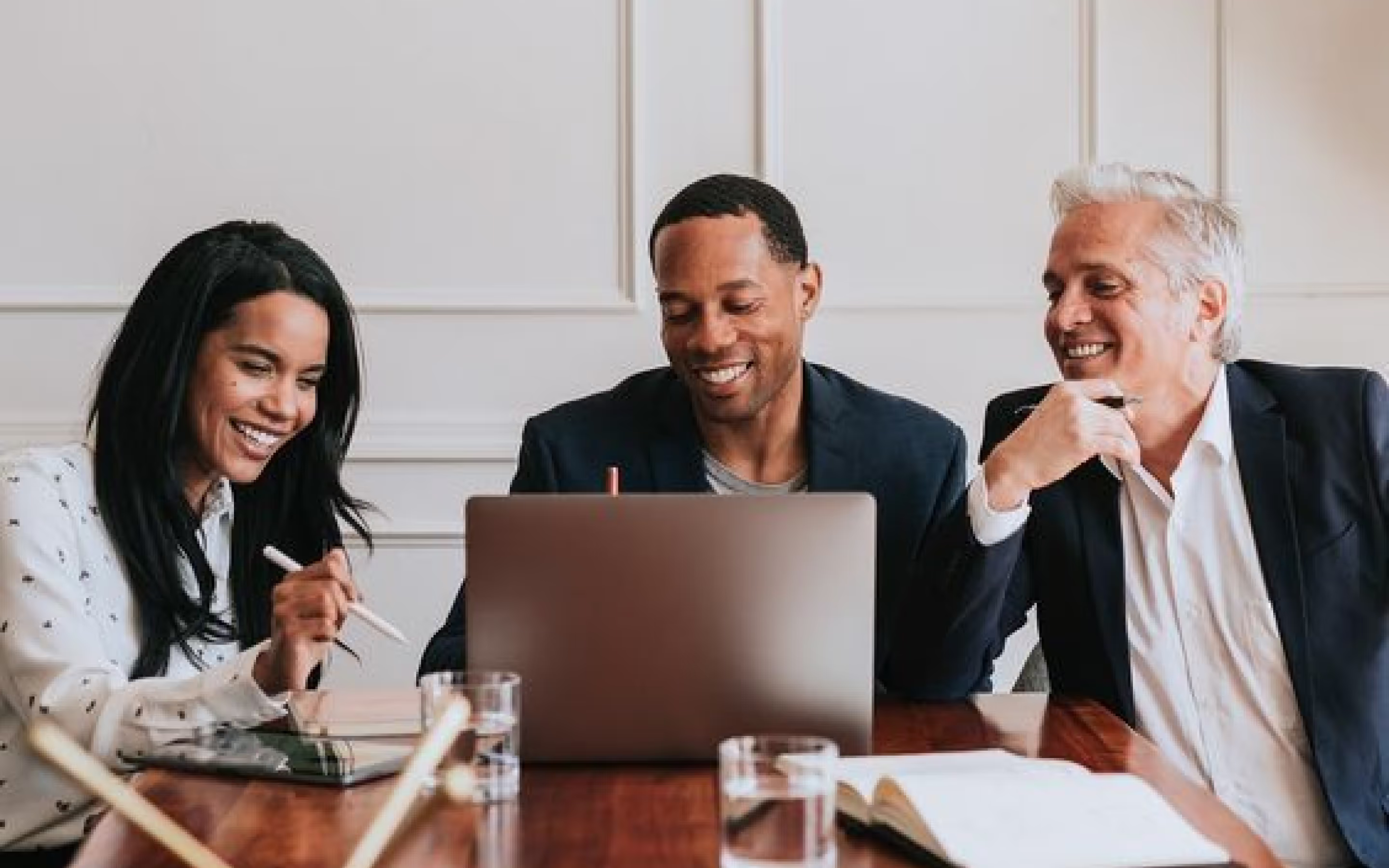 three people looking at laptop screen