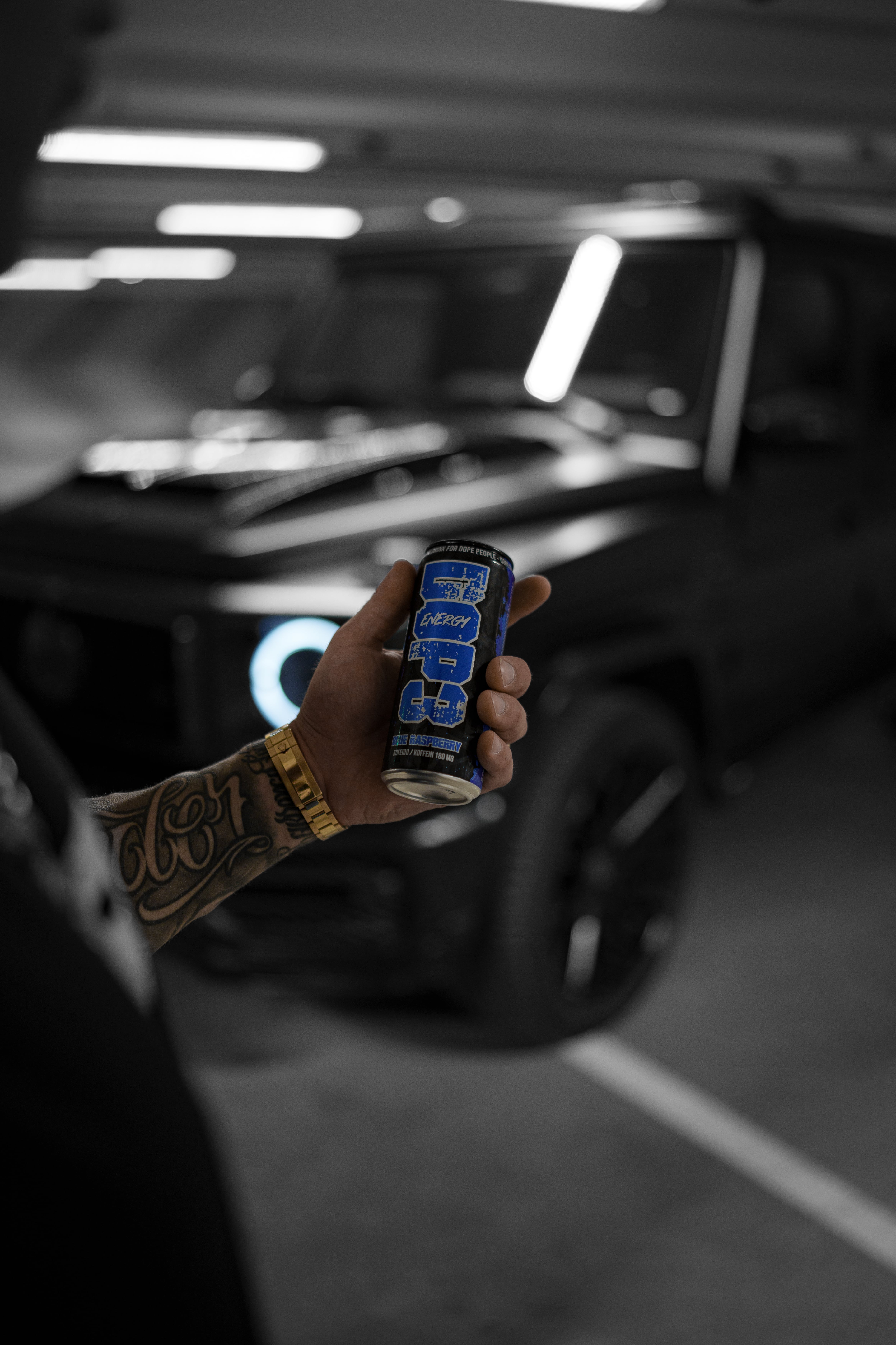 DOP3 Energy can in front of a black car in a parking garage