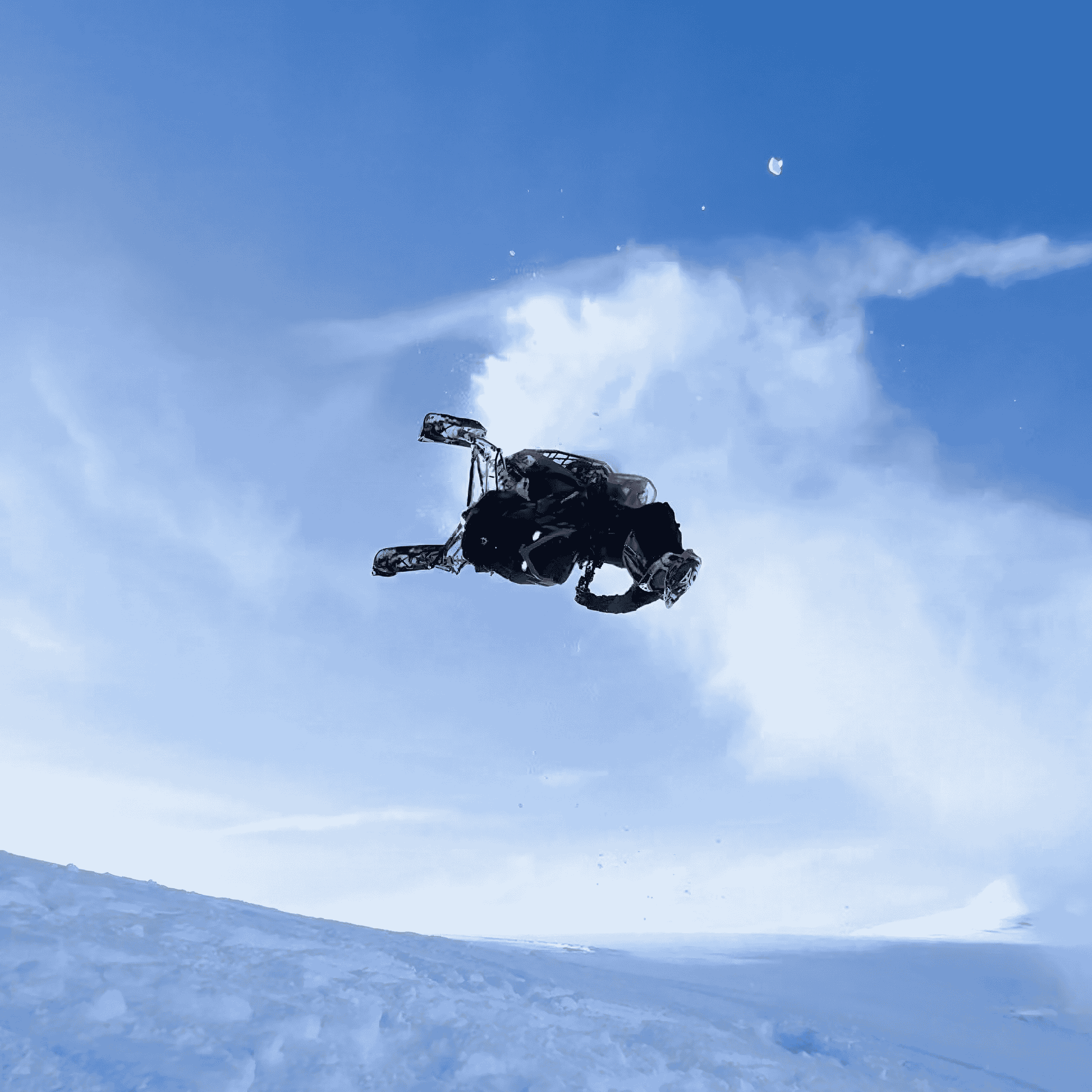 Snowboarder wearing helmet and gear performing a high airborne trick against a blue sky with clouds.