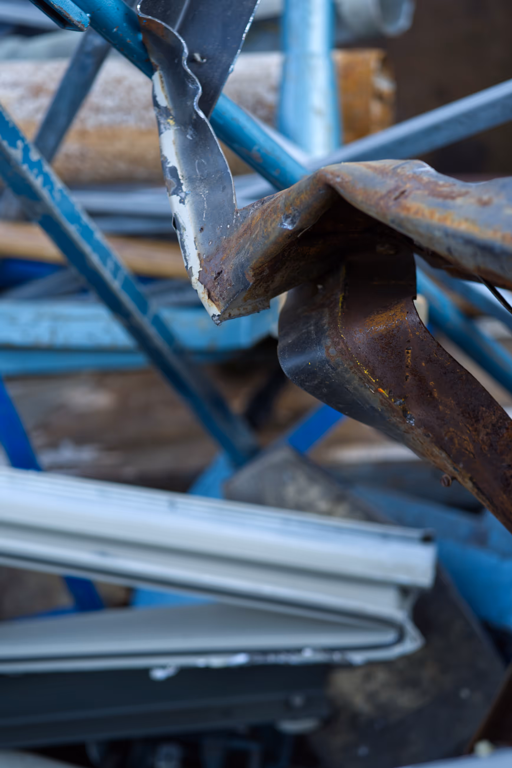 Verformte und teils rostige Metallprofile, gestapelt auf einem Recyclingplatz