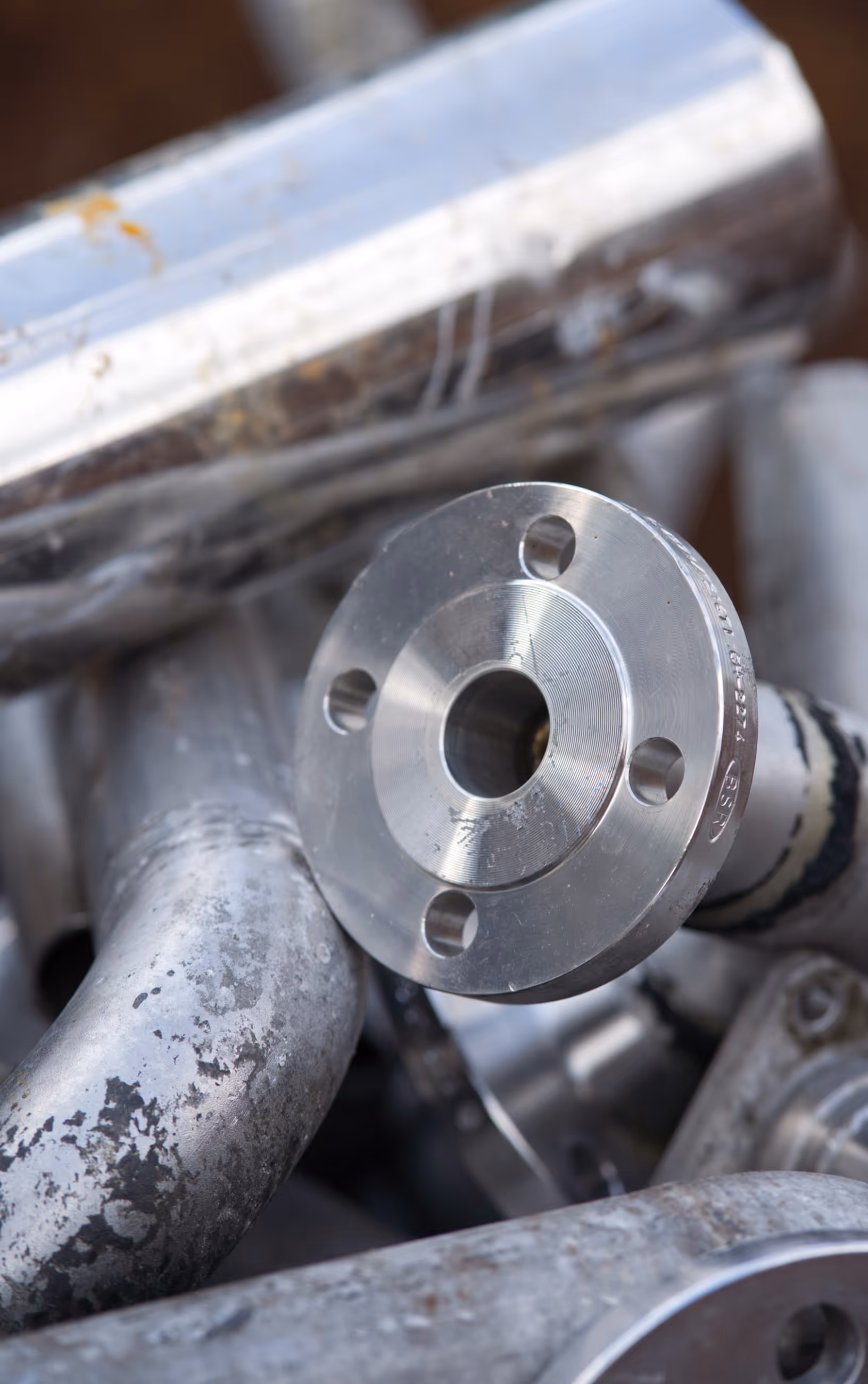 Nahaufnahme von sortiertem Aluminiumschrott, im Vordergrund ein glänzender Flansch mit Bohrungen