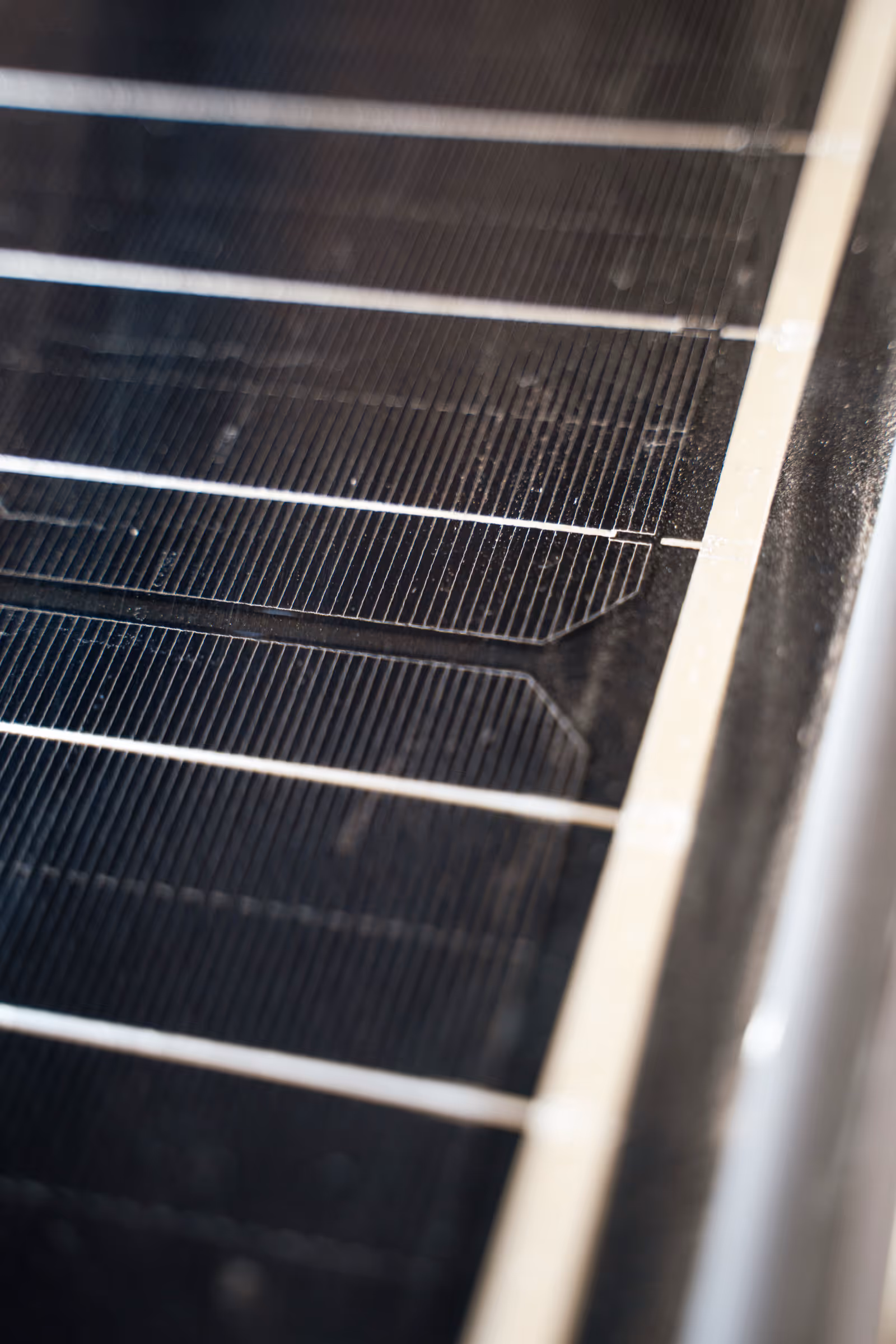 Nahaufnahme der Oberfläche eines Solarmoduls mit sichtbaren Zellen und feinen Leiterbahnen