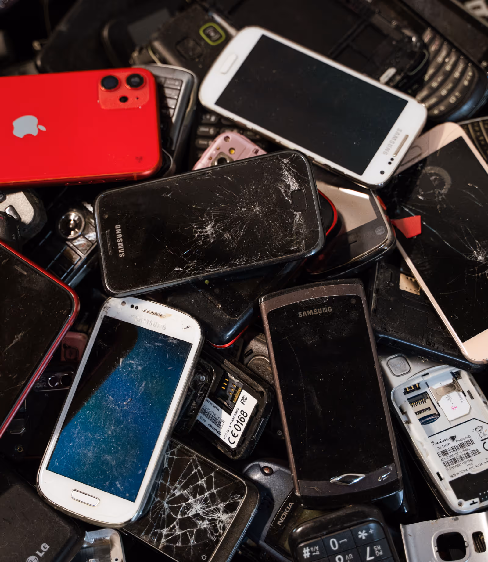 Viele kaputte Smartphones liegen zusammen in einer Box