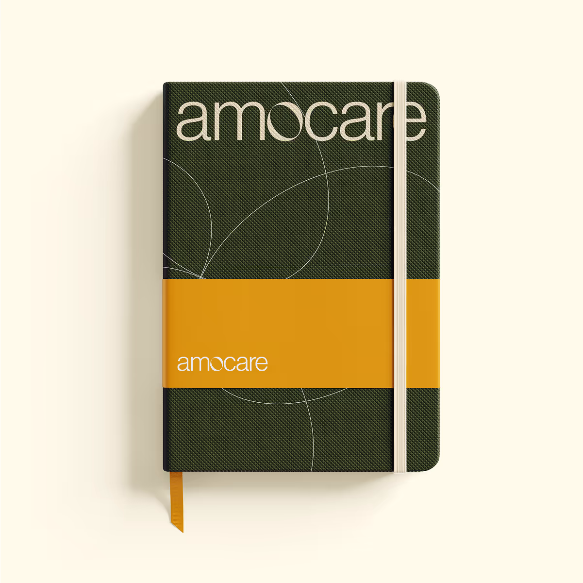 Closed dark green textured notebook with white elastic band and orange belly band labeled amocare.