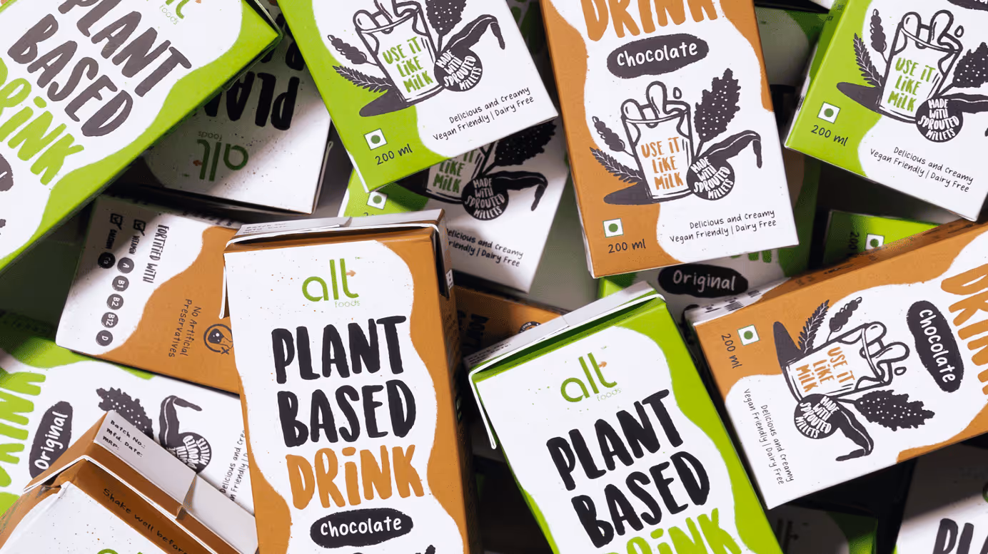 Multiple cartons of alt foods plant-based drinks in chocolate and original flavors, packed together.