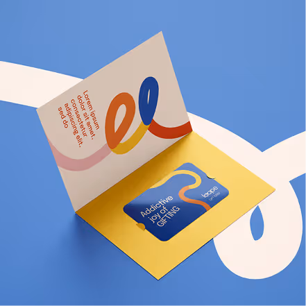 Open gift card holder with colorful abstract design and text 'Addictive joy of GIFTING' on a blue and yellow background.