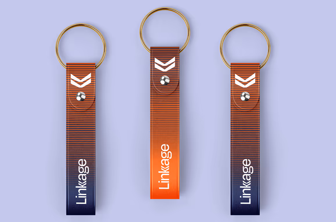 Three red and blue gradient keychains with gold rings, each displaying a white chevron logo and the word 'Linkage' on a lavender background.