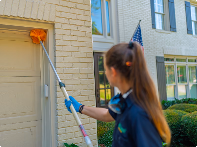 pest control tech treating the exterior of a home in georgia
