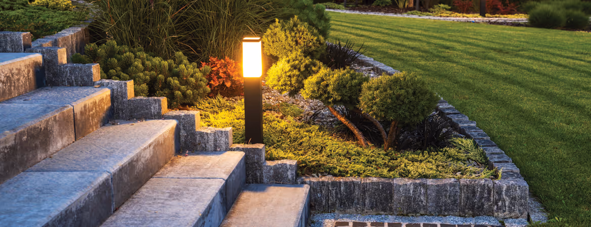 Backyard landscape with stone steps and cut grass at night