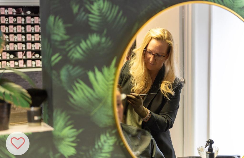 Julie colouring a client's hair, reflected in the mirror