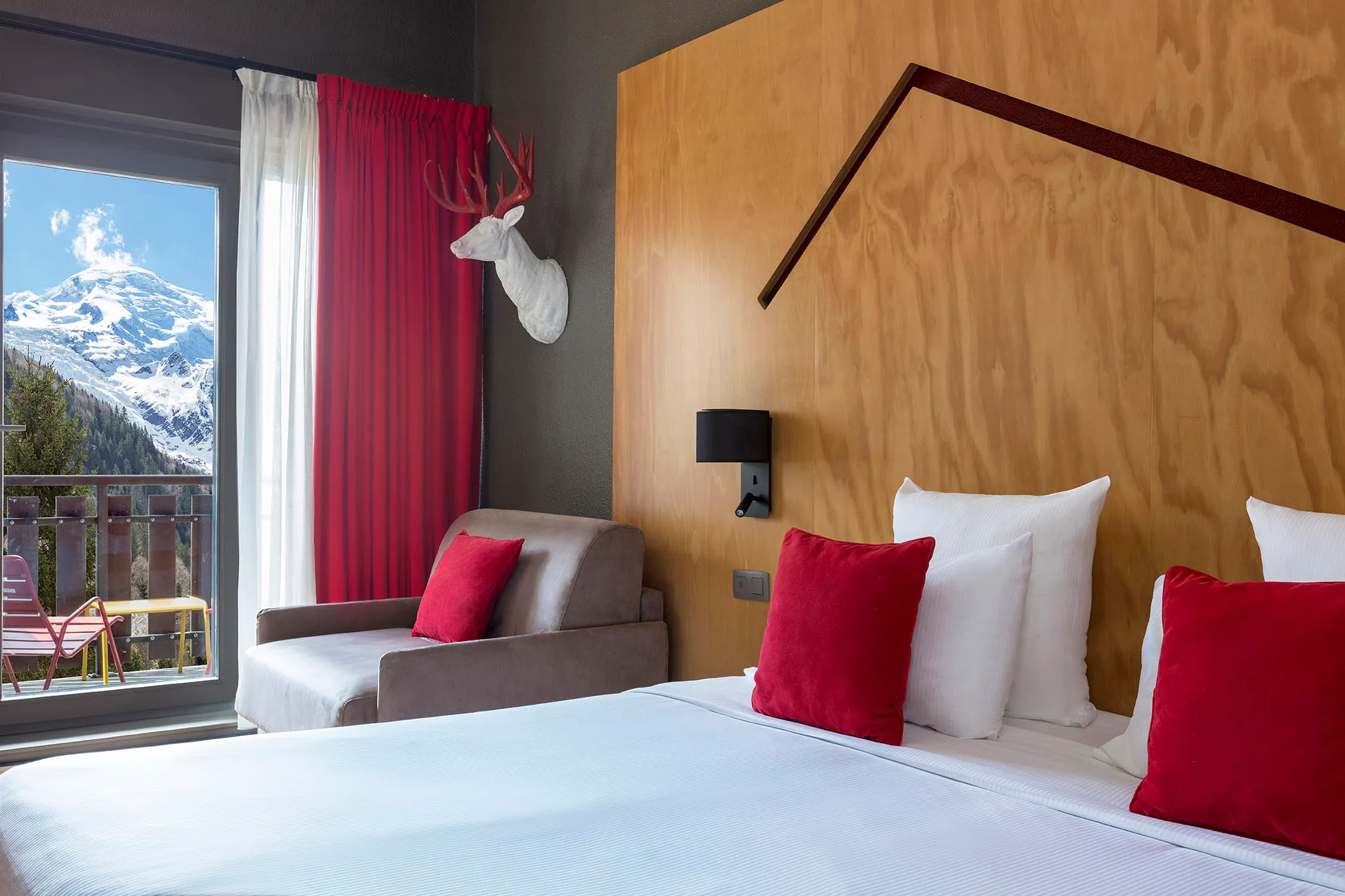 Chambre Supérieure Mansardée avec grand lit et vue depuis la fenêtre de l'hôtel Les Aiglons à Chamonix