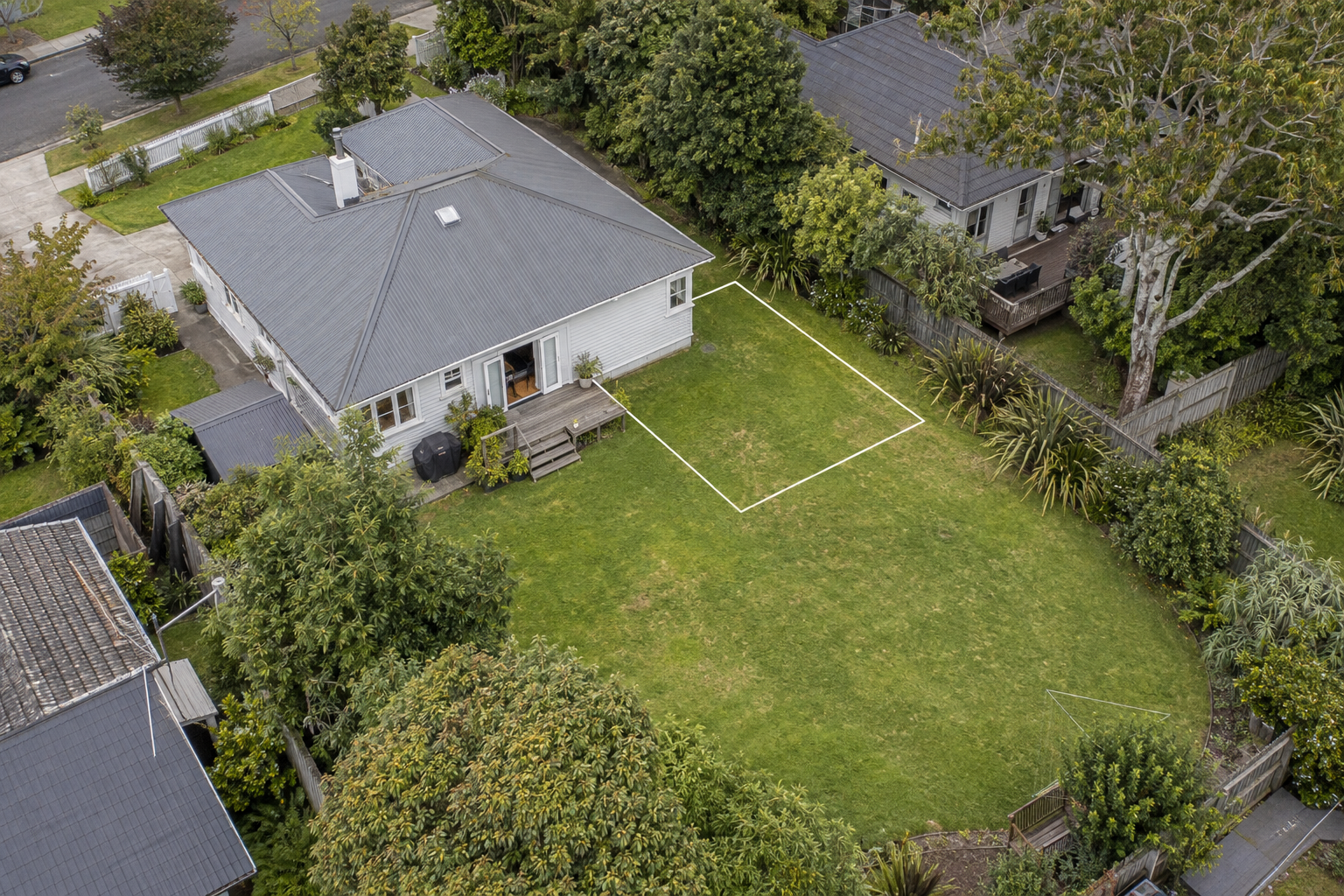 Illustrative aerial of an existing home with an outlined potential extension area.