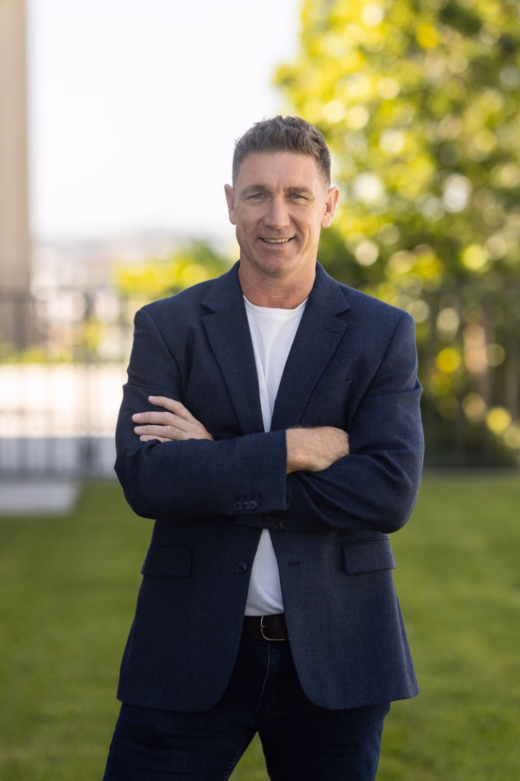 Successful real estate agent posing outdoors in front of property