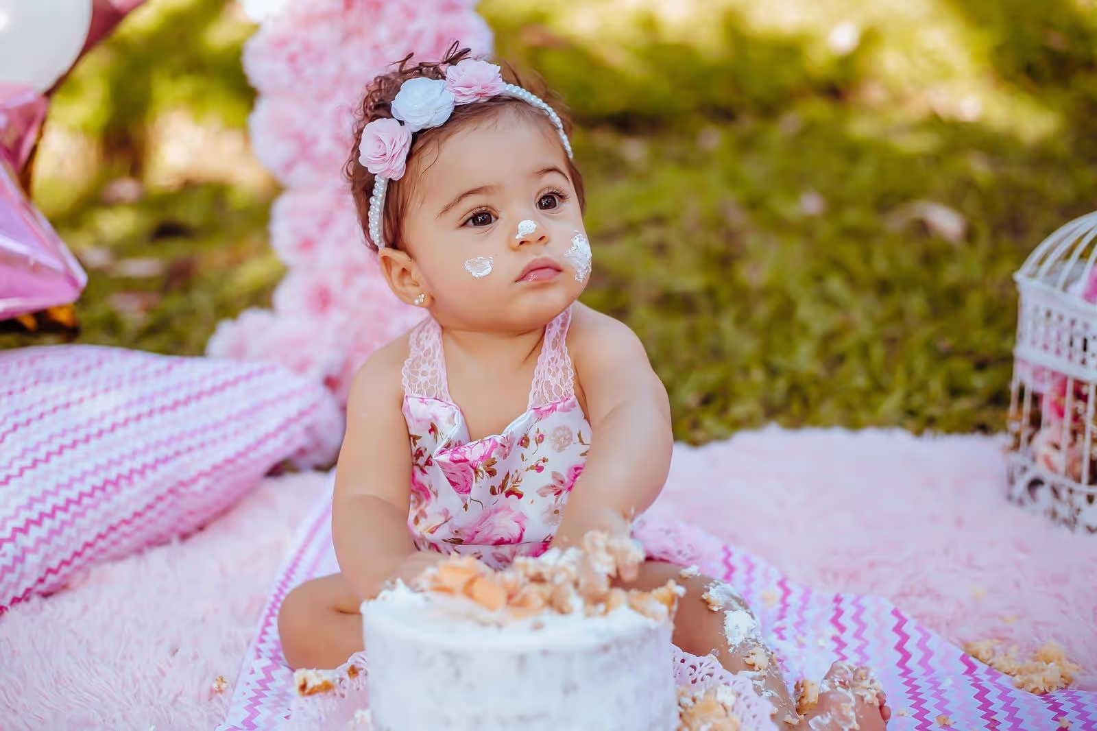 Outdoor-Picknick zum 1. Geburtstag mit Geburtstagstorte, Picknickdecke, Boho-Kissen und Ballonsn – liebevoll inszeniert von Babybloom Wien