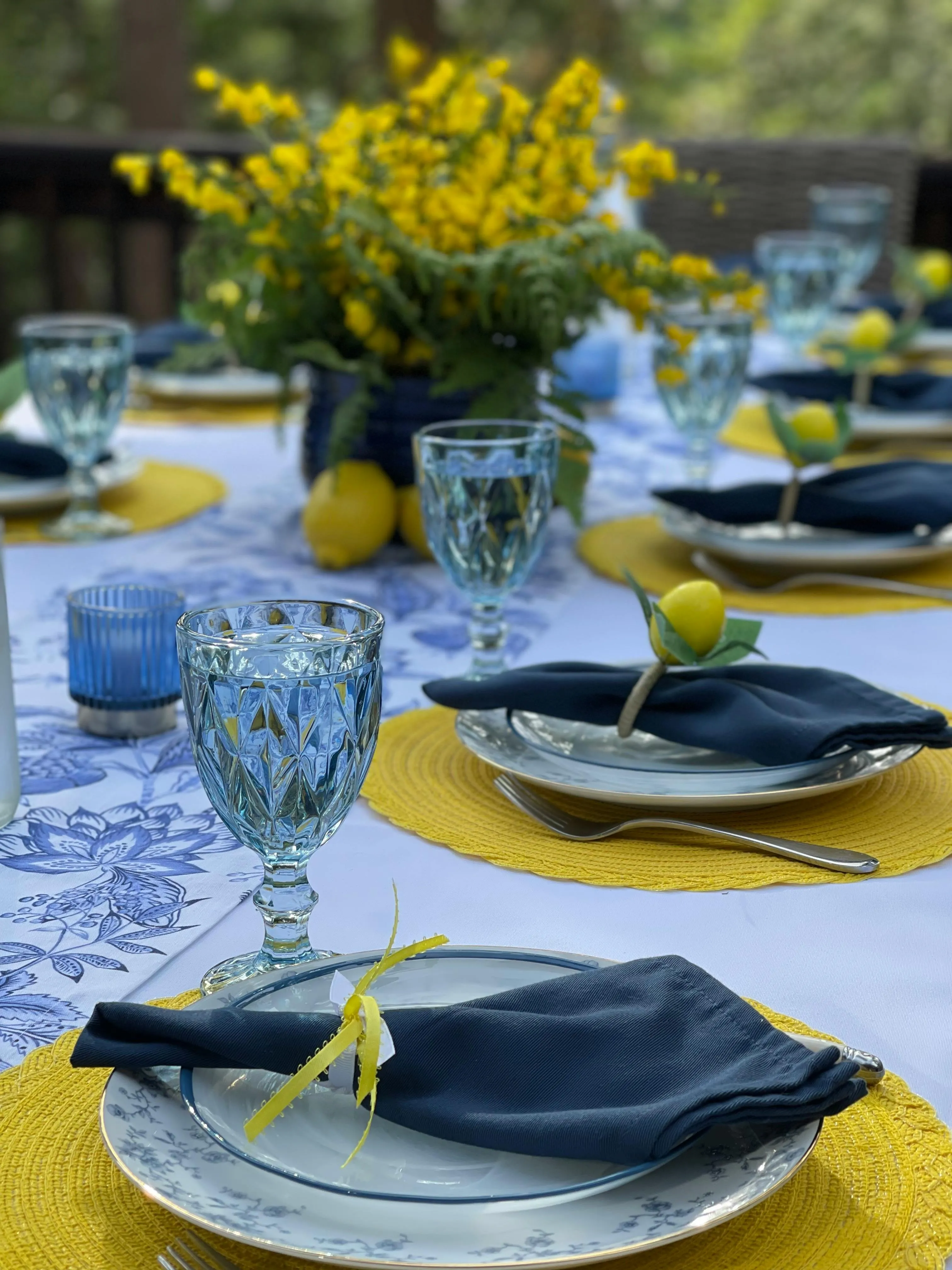 Stilvolle Tischdekoration zur Baby Shower mit Namenskärtchen, Blumendekoration und gelb blauenDetails – gestaltet von Babybloom Wien