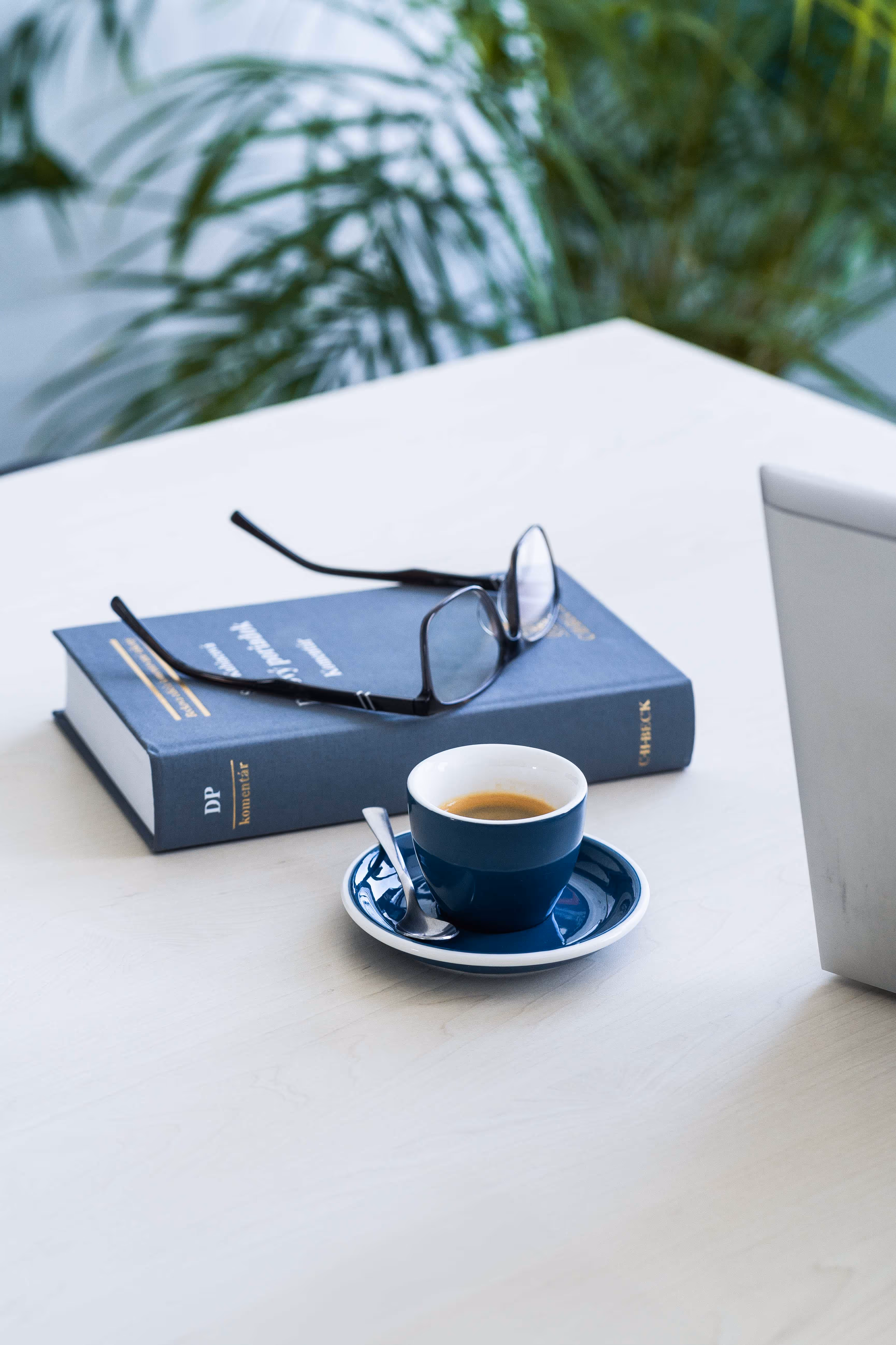 A laptop computer sitting on top of a table next to a cup of coffee