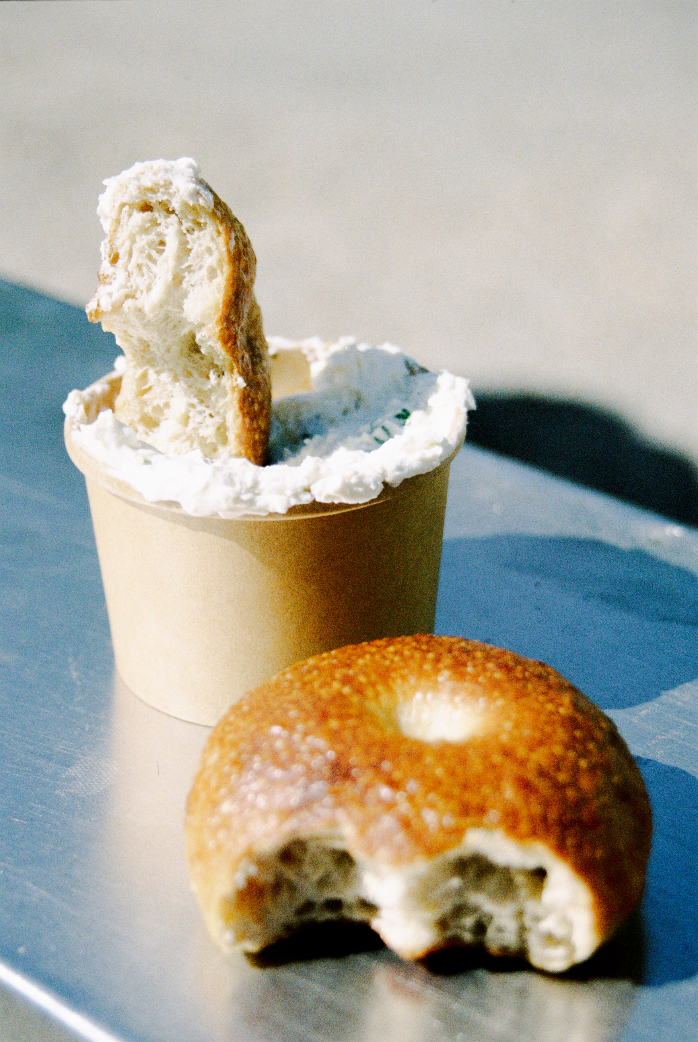 A rip and dip bagel being dipped in sauce.