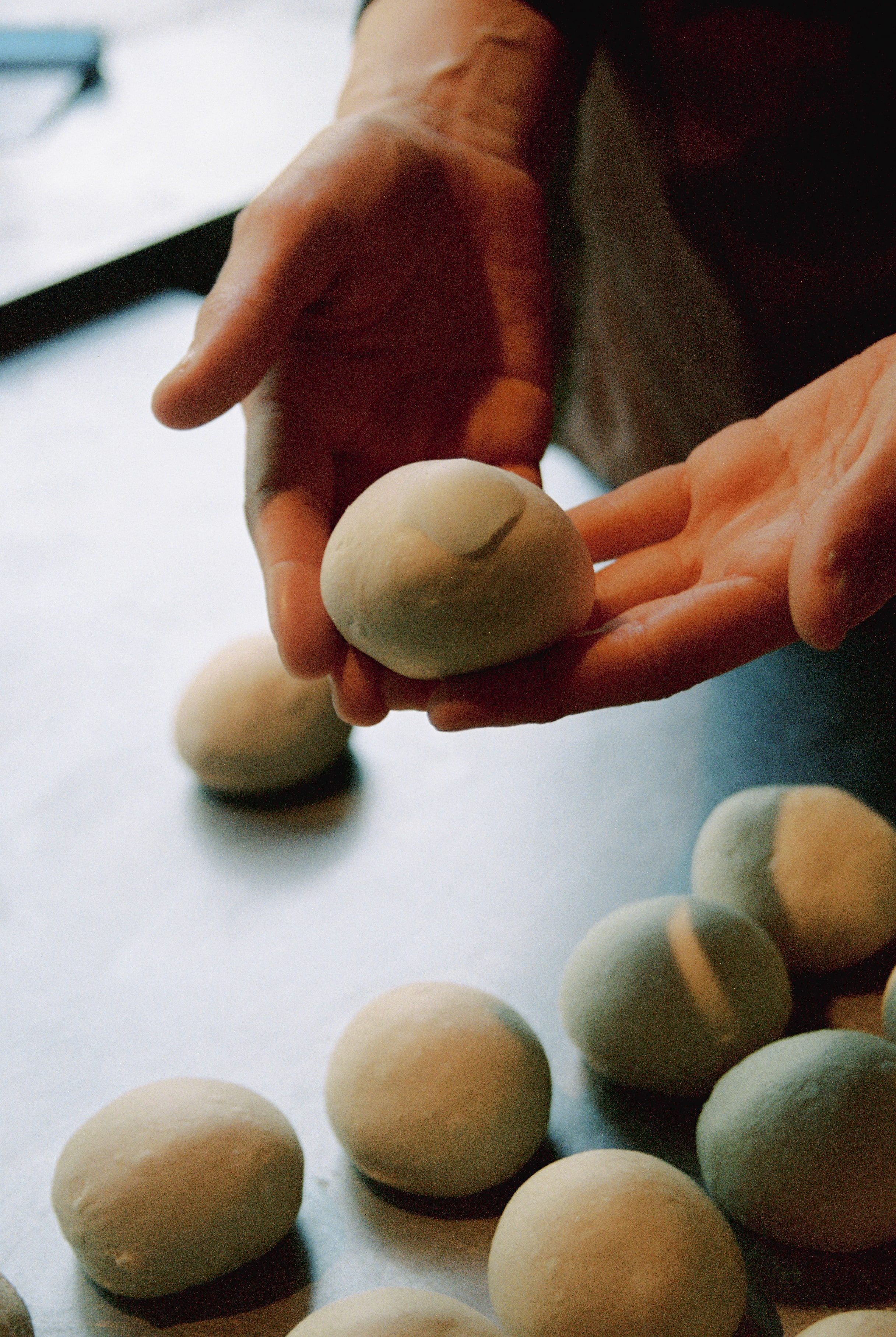 An image of bagels being baked from dough balls. 