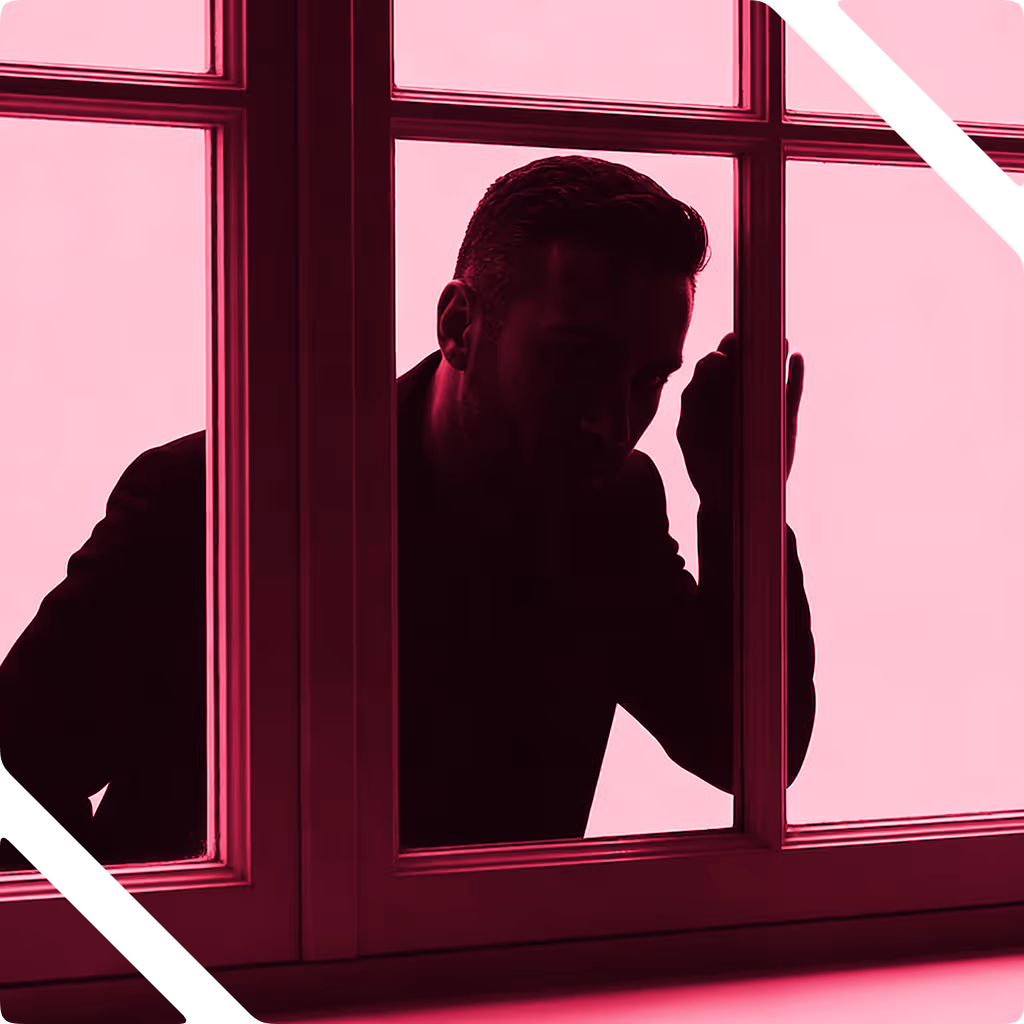 Silhouette of a man looking through a window framed by dark pink light.