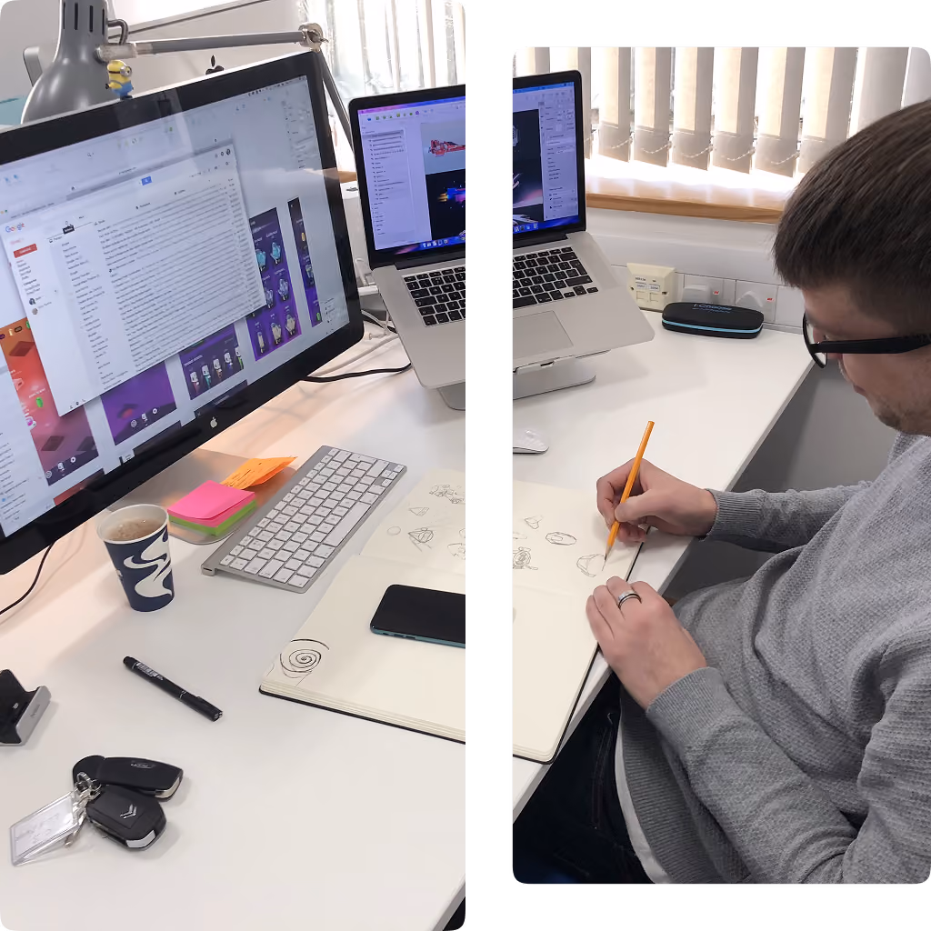 Man sketching designs by hand at a desk with two laptops, sketches, coffee, and office items.