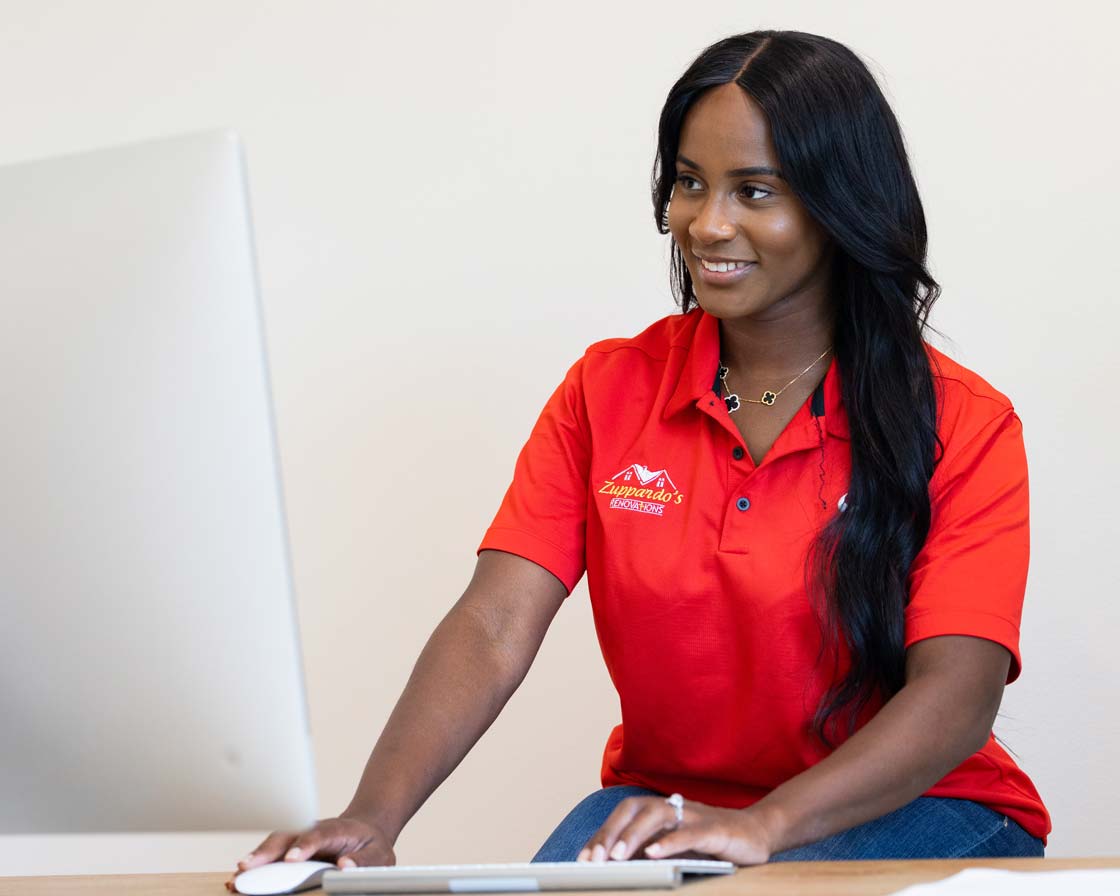 Woman who represents Zuppardo's Renovations smiling looking at computer