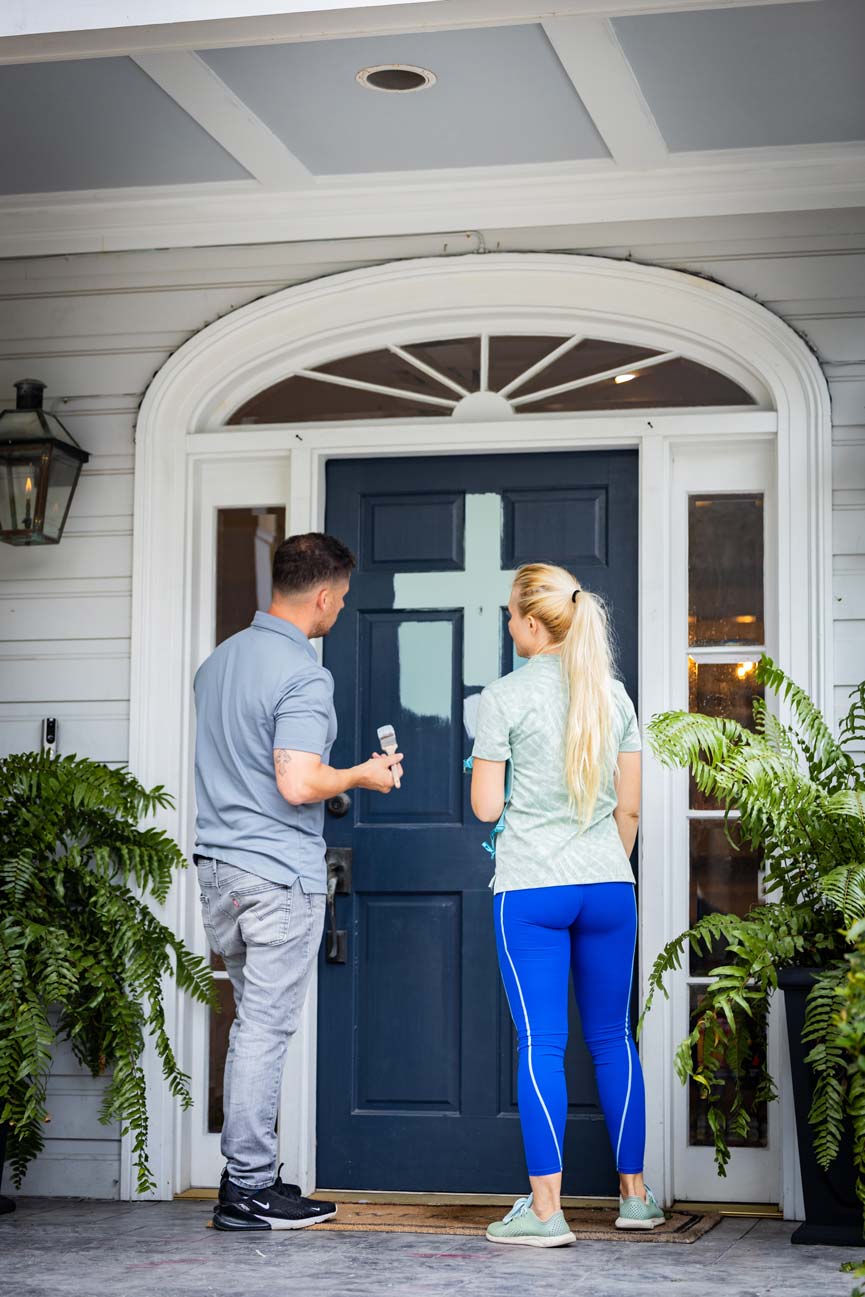 Couple painting exterior door frame
