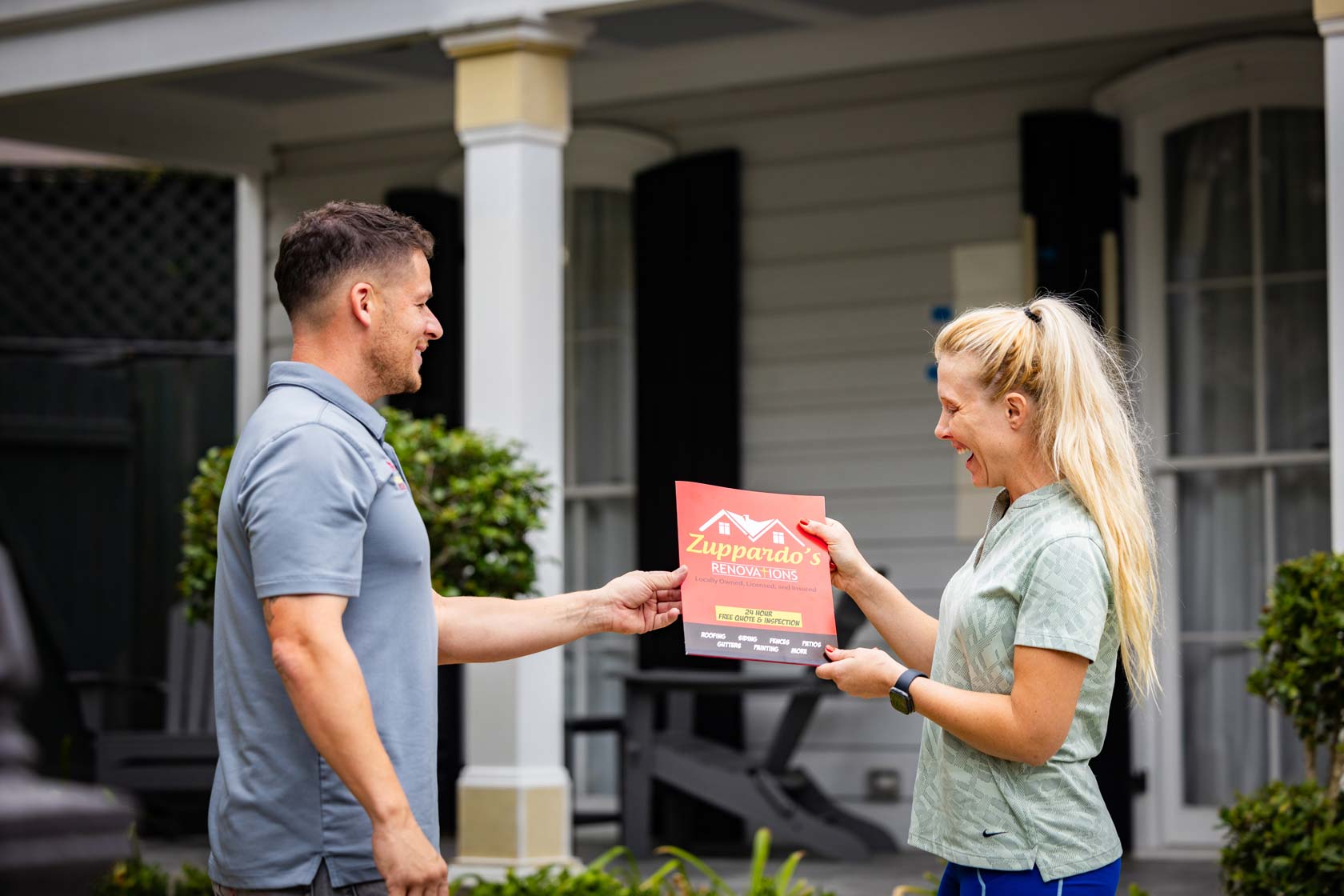 Man presenting a Zuppardo's Renovations flyer to woman at house