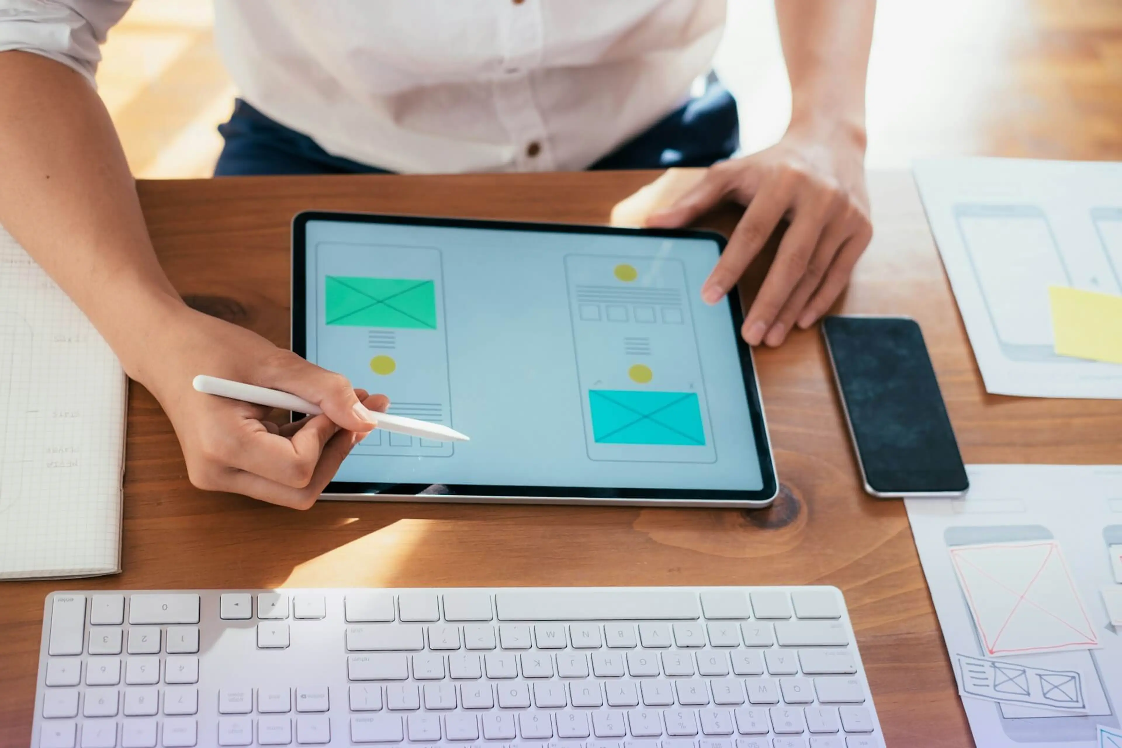 Person designing website wireframes on a tablet
