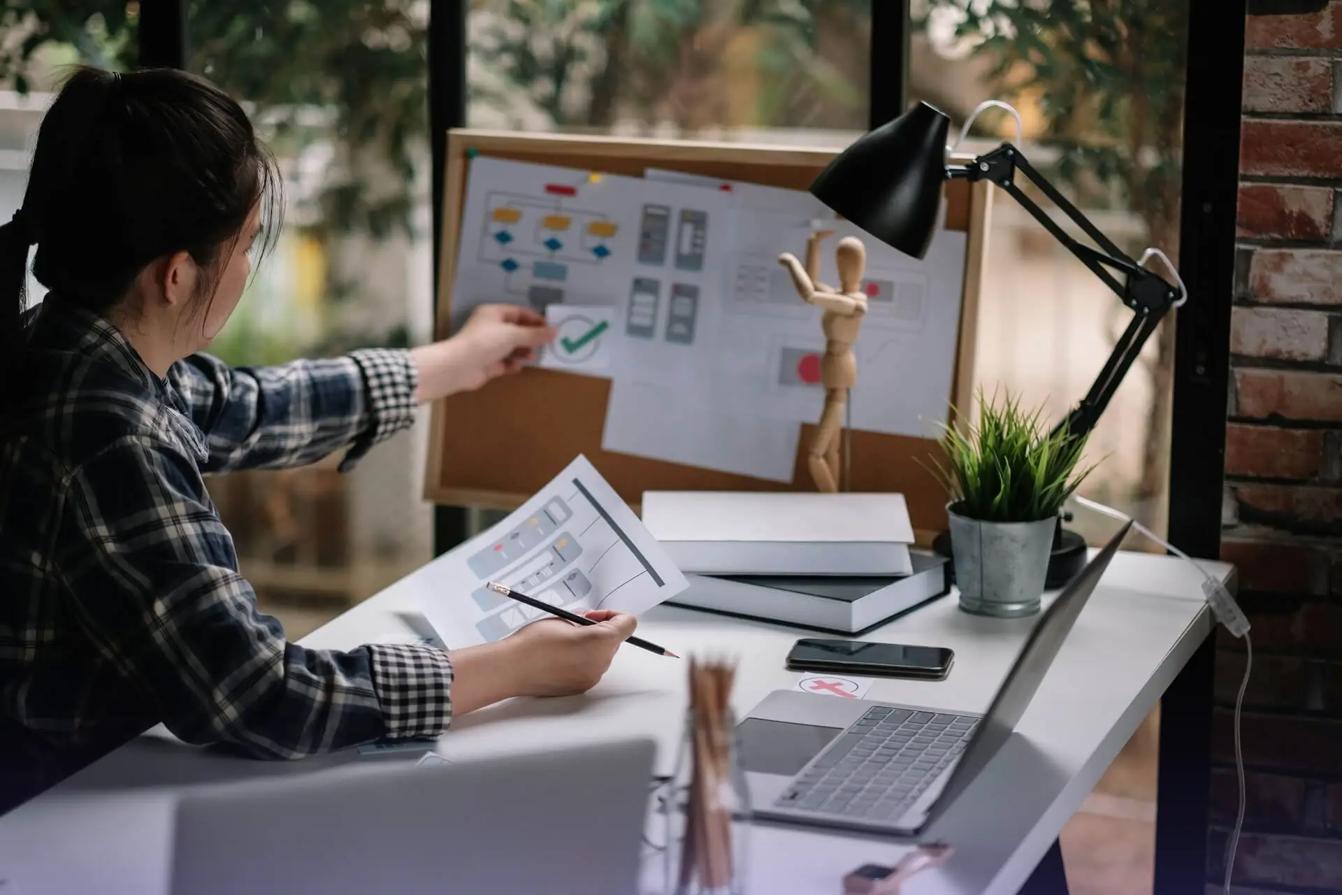 Person reviewing wireframes and user flow diagrams at a desk
