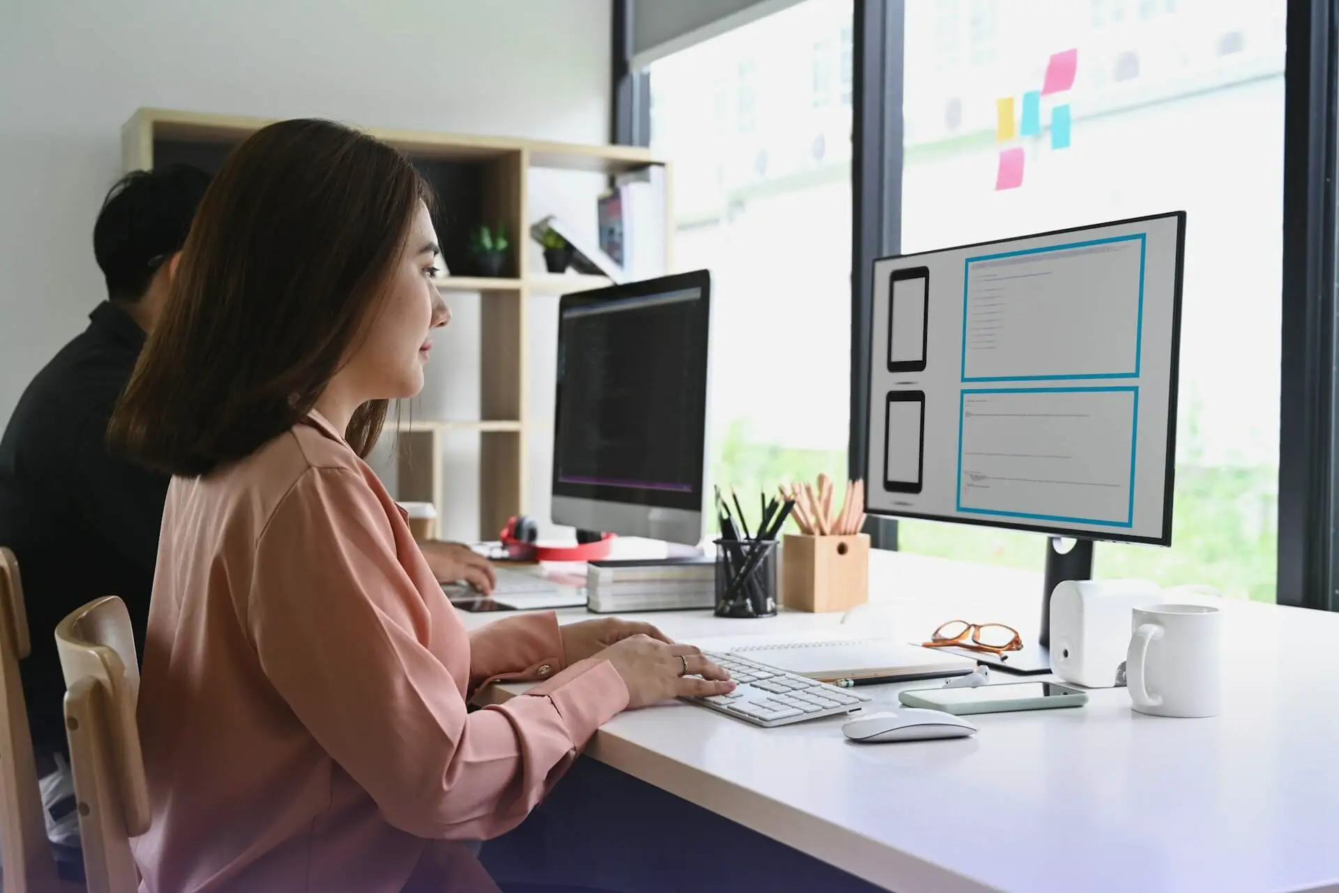 Person working on wireframes at a desk in a modern office