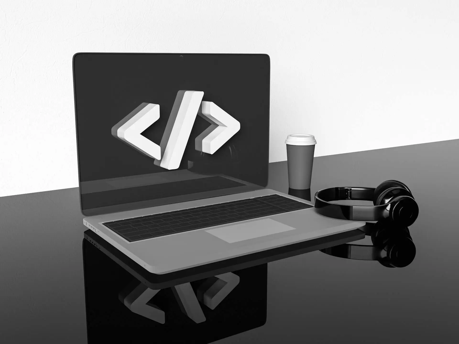 Minimal workspace with a laptop displaying a 3D code symbol on screen