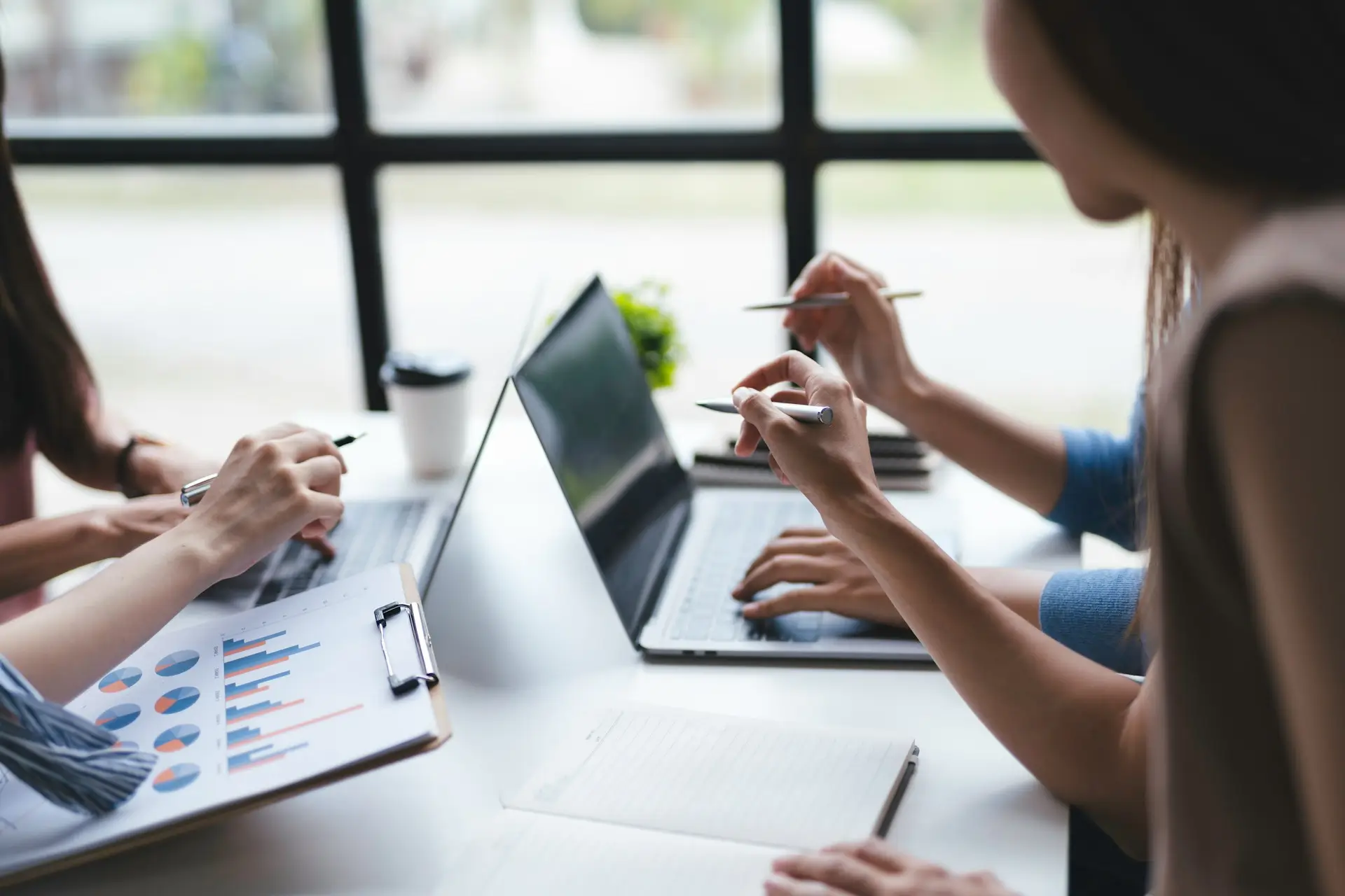 Team working together on laptops reviewing data and discussing project.