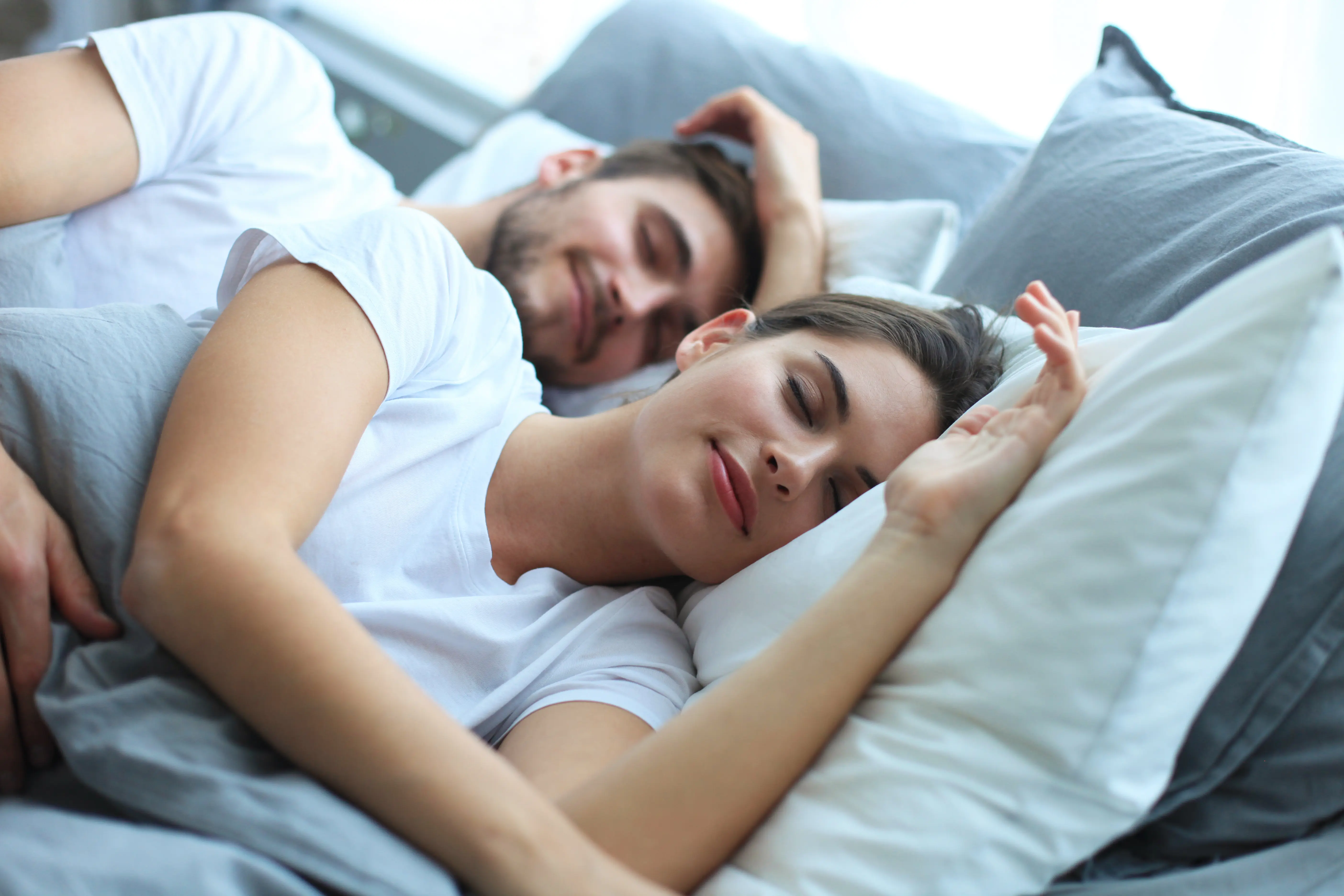 Couple sleeping peacefully together in bed