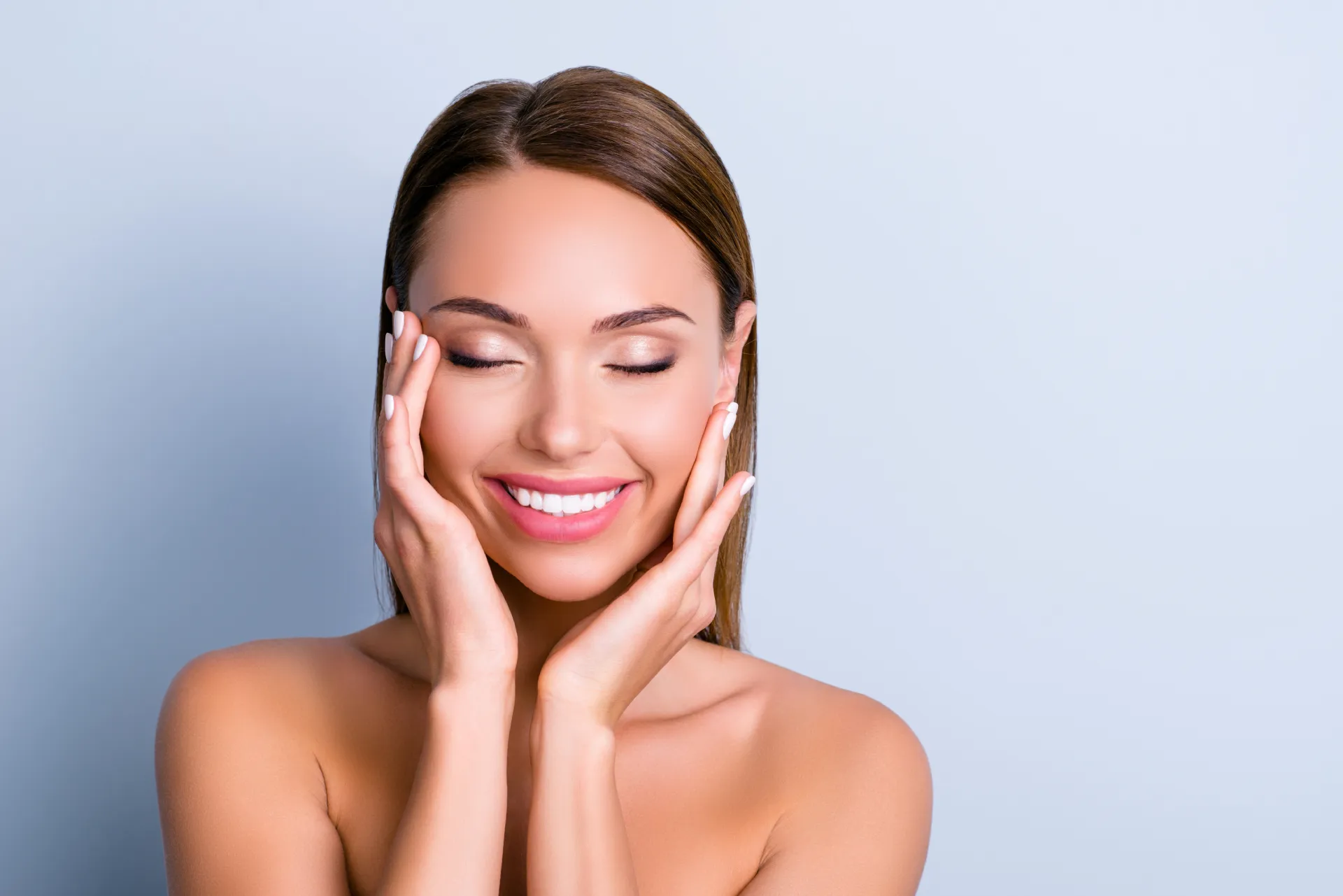 Smiling woman gently touching her face