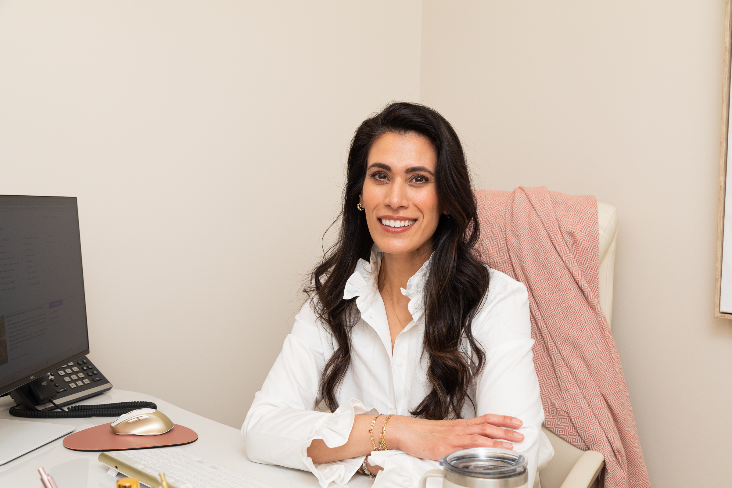 Dr. Ekta Sem smiling at her desk at Rituals Dental Wellness & Aesthetics in Blue Bell, PA