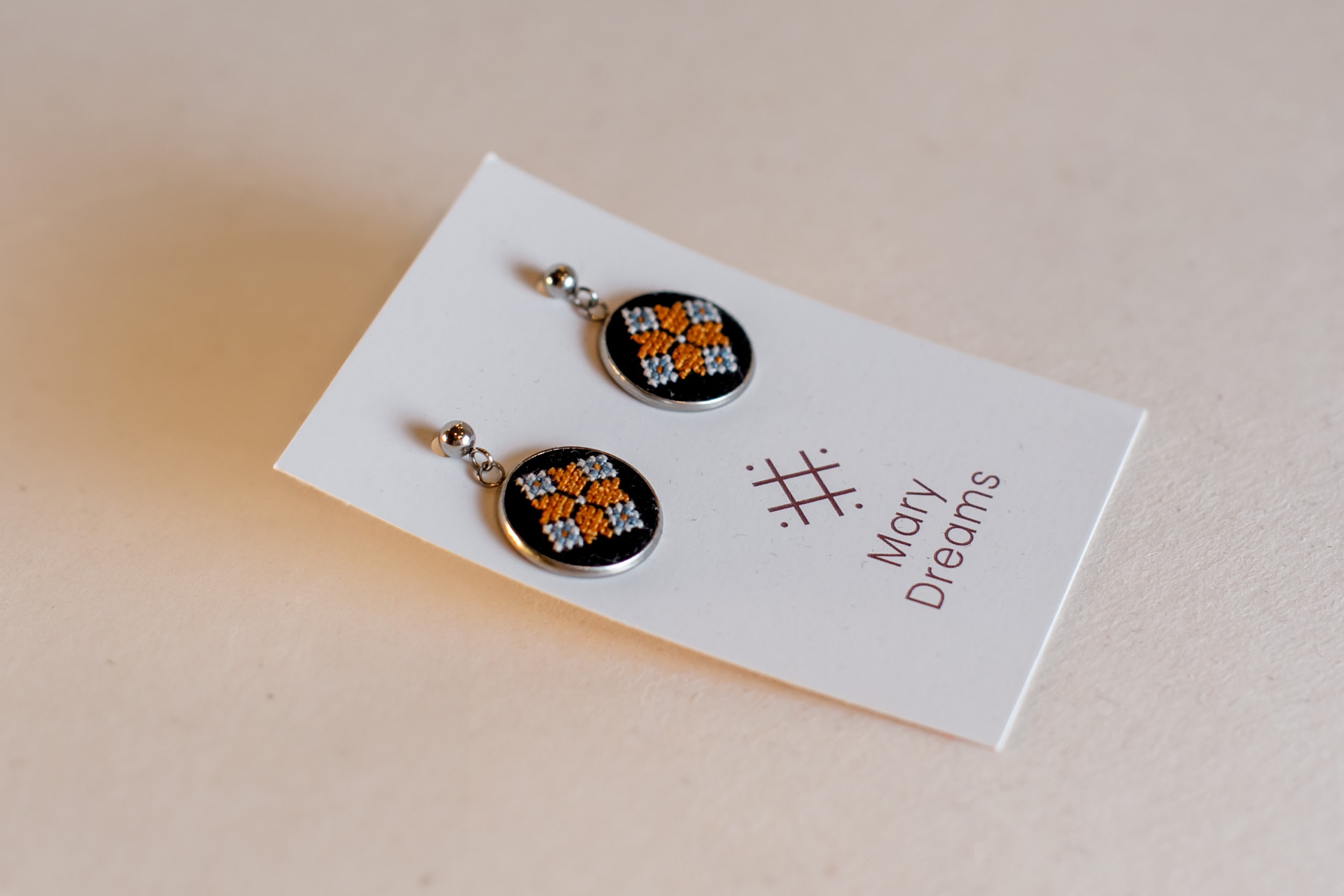 Hand-made earrings with micro cross stitch embroidery