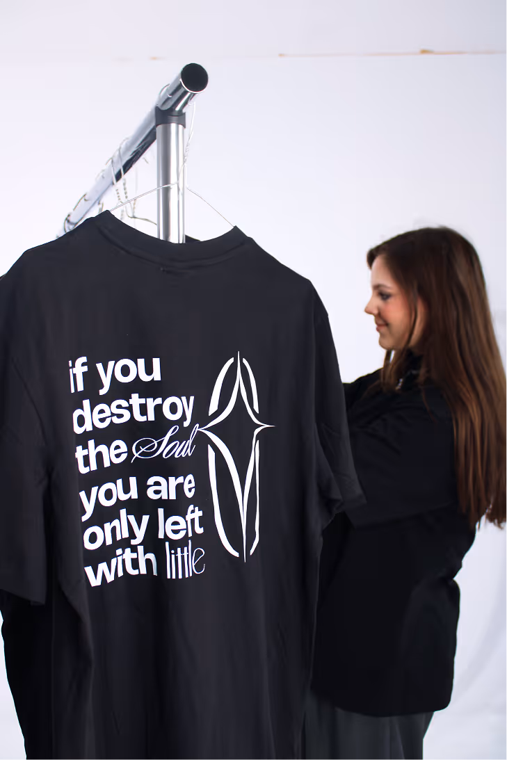 Black t-shirt on hanger with text 'if you destroy the Soul you are only left with little' and abstract design.
