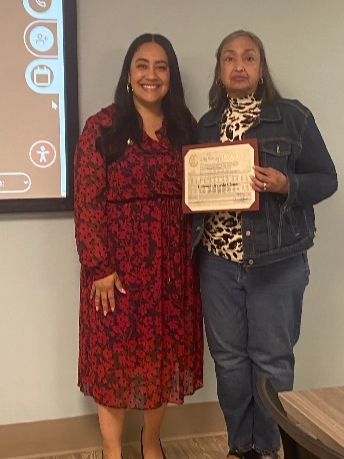 Two women posing with a City Council citation certificate