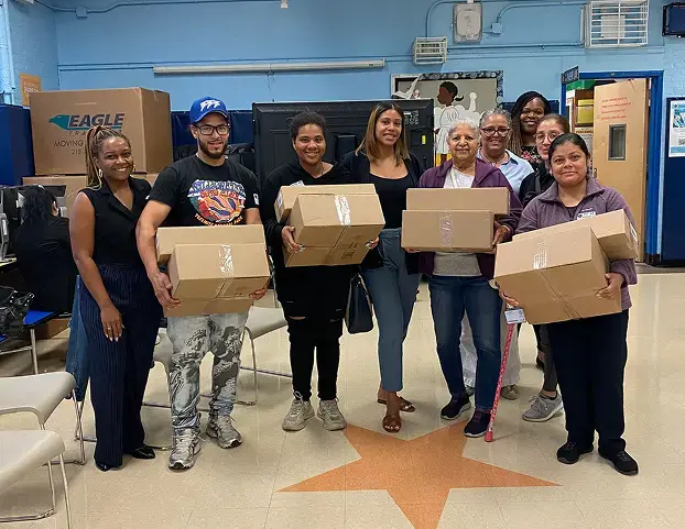 Community members receiving donated boxes at a school distribution event