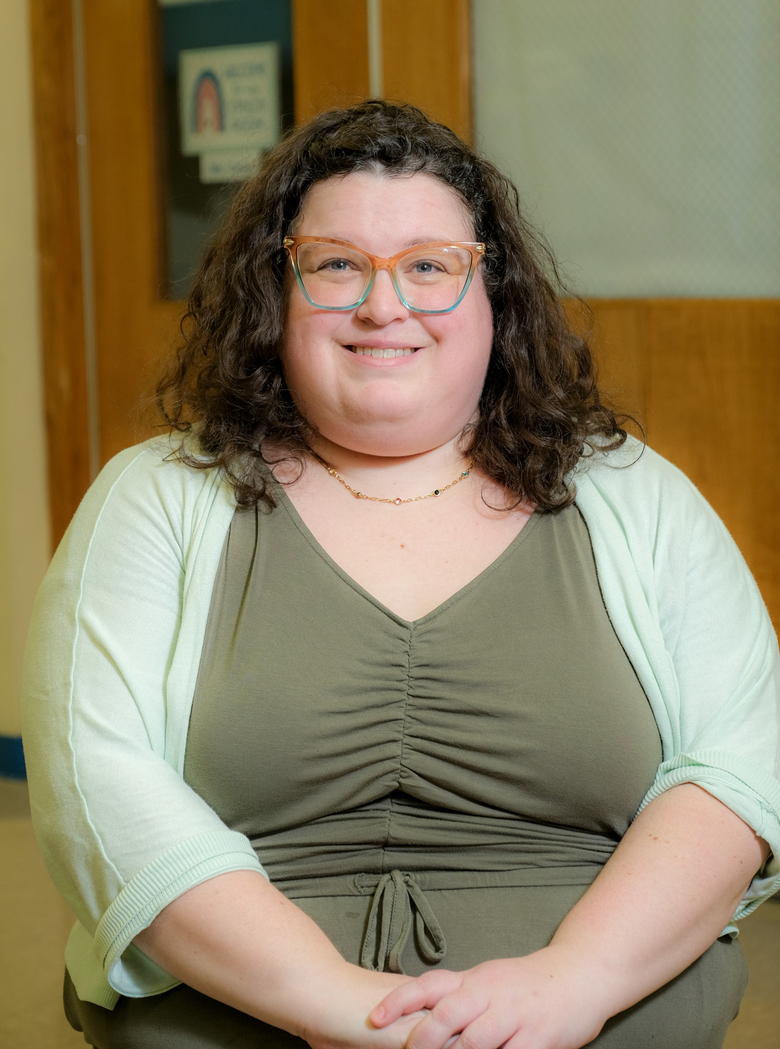 Meridith Emmer smiling in school hallway wearing glasses