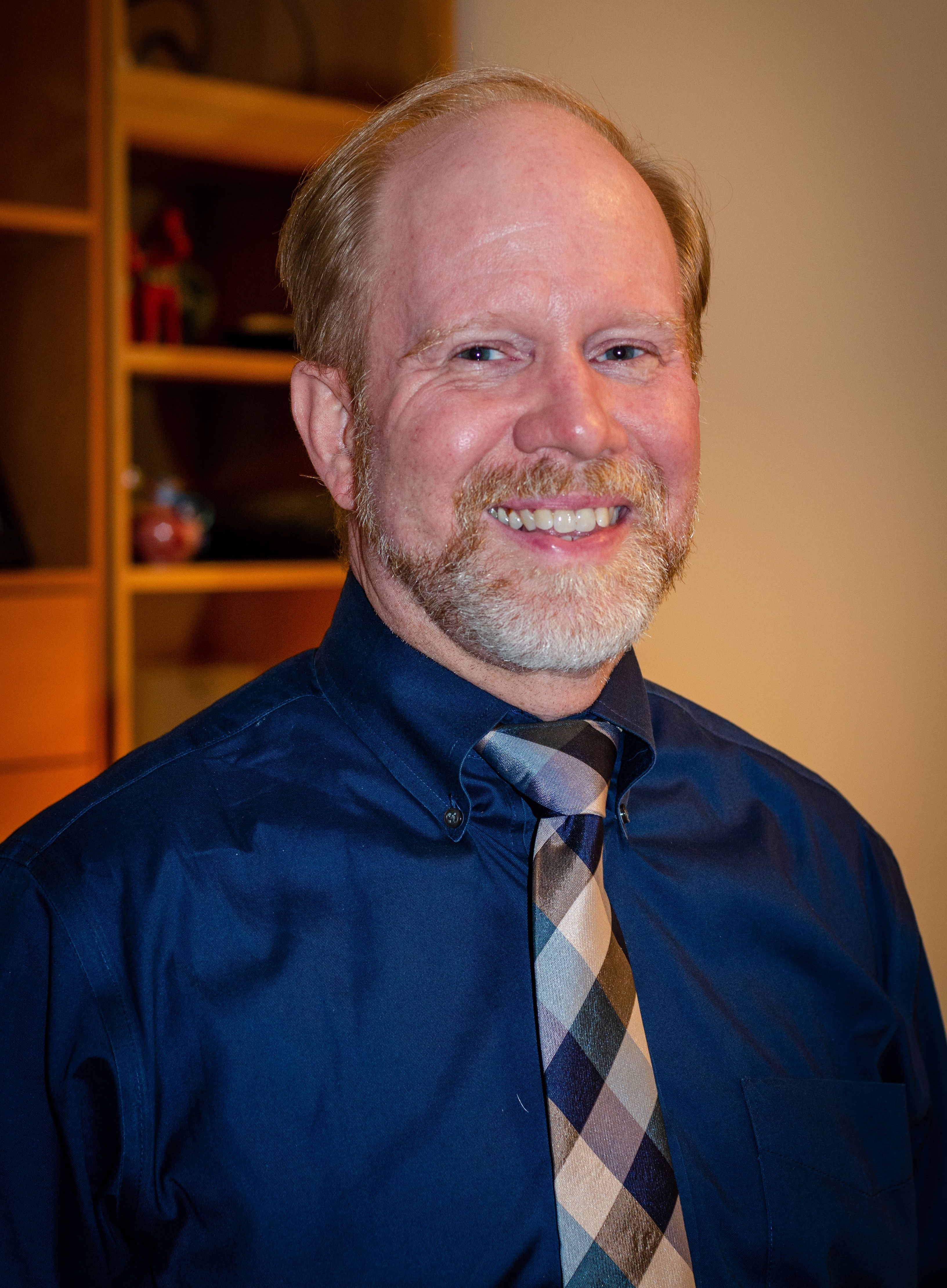 Robert Hemstreet smiling in blue shirt and plaid tie